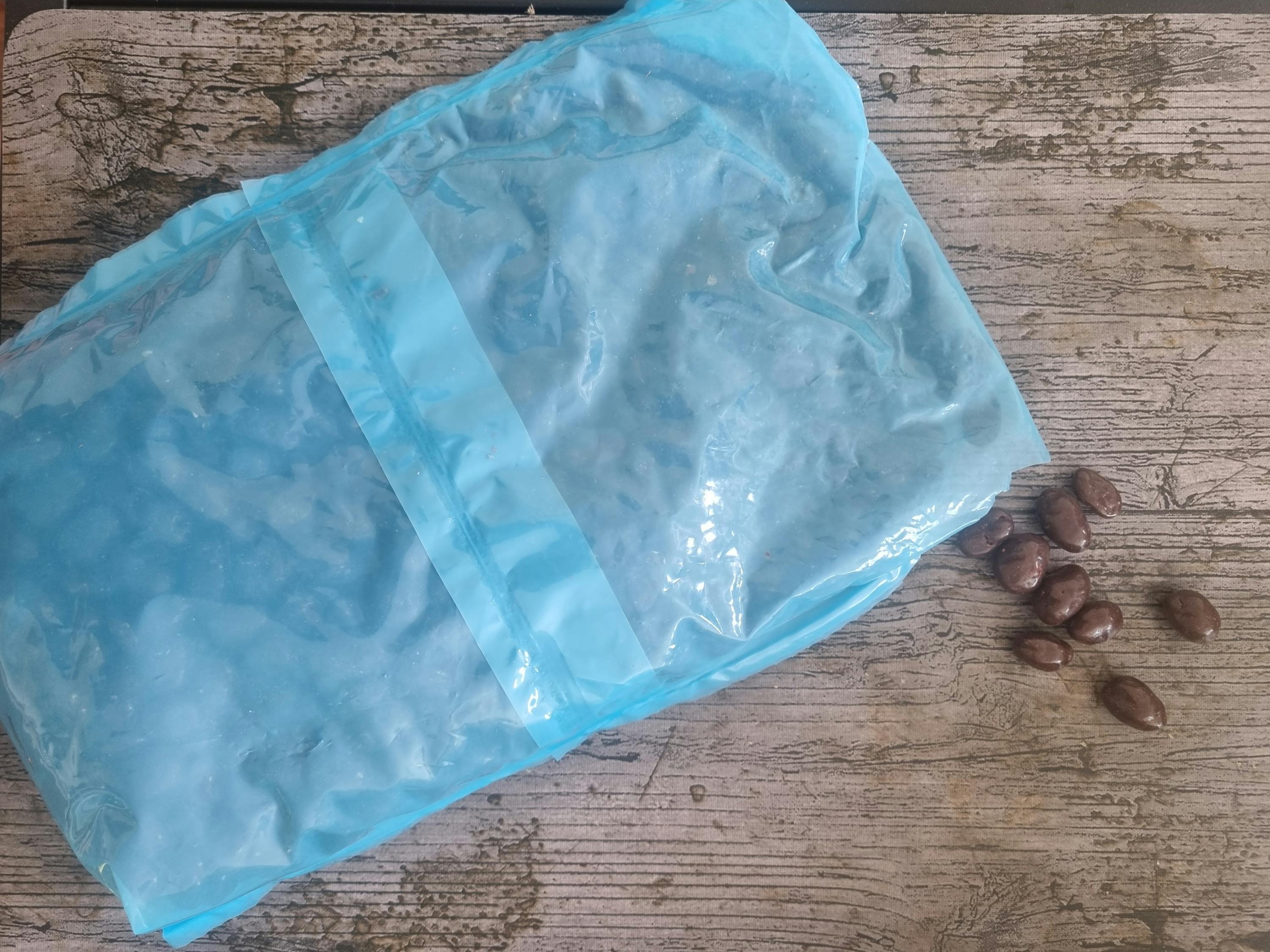 ein blauer Plastikbeutel liegt auf einem Holztisch