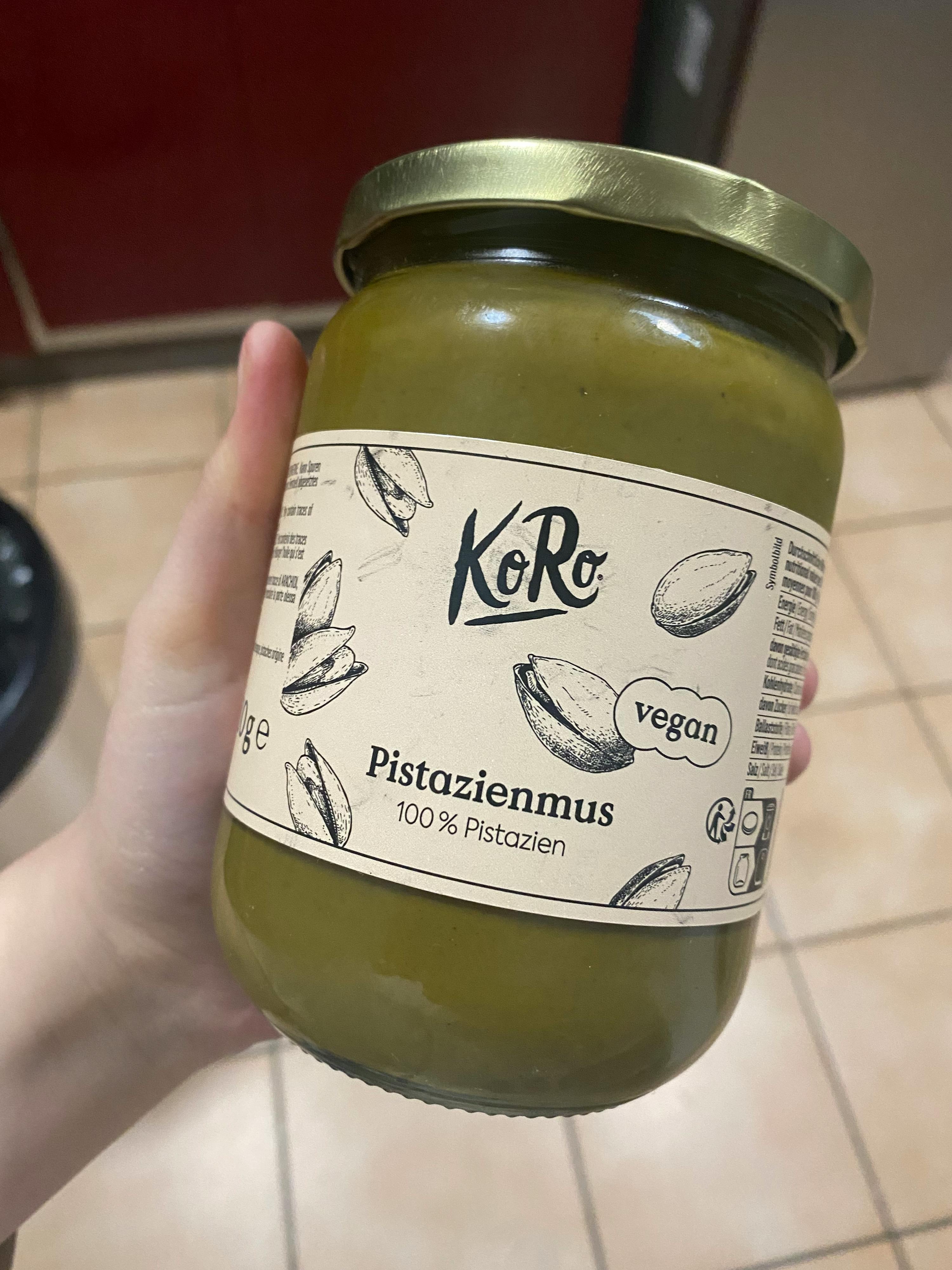 une personne tient un bocal de pistazienmus vegan
