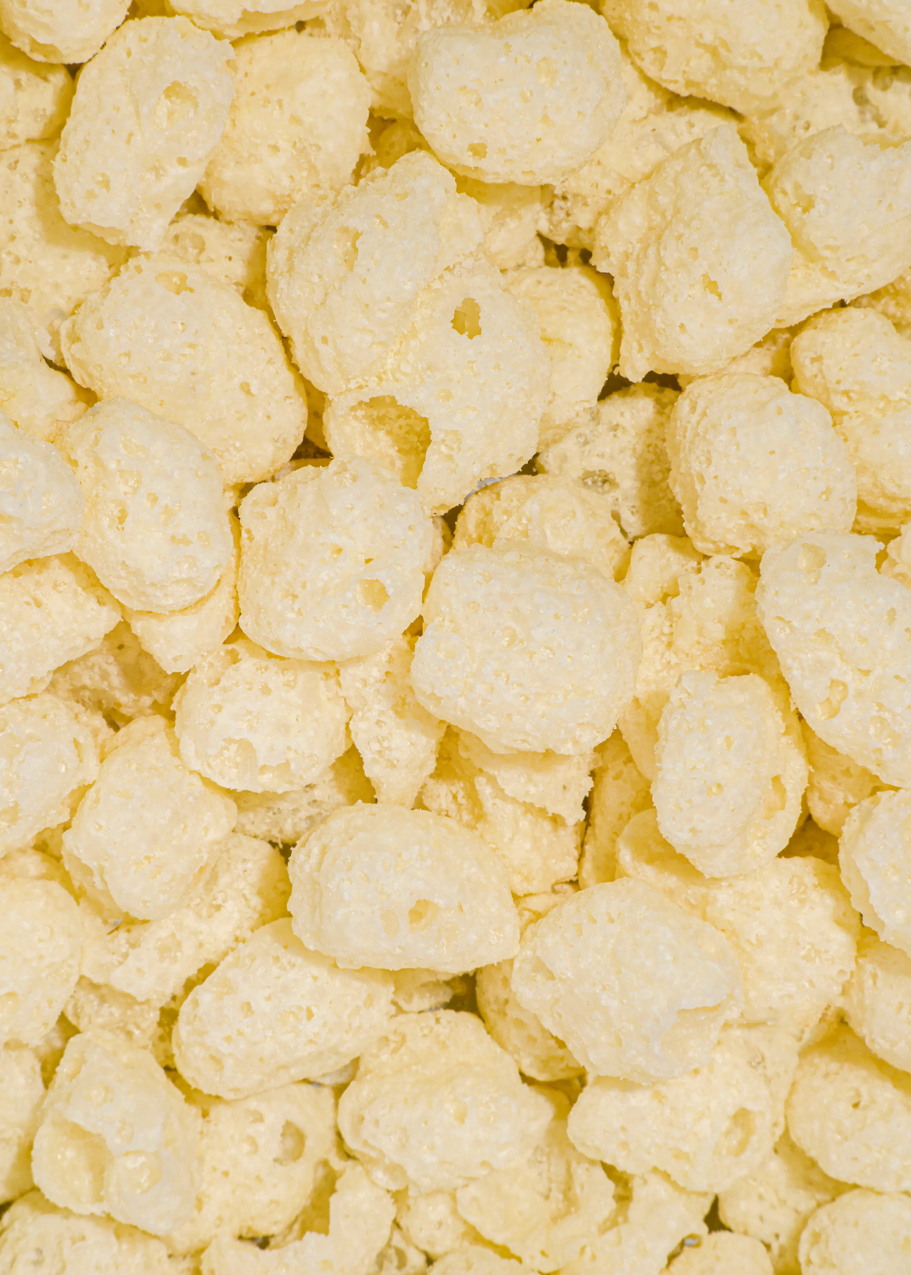 primo piano di cereali croccanti di mais di colore giallo chiaro dalla consistenza porosa.