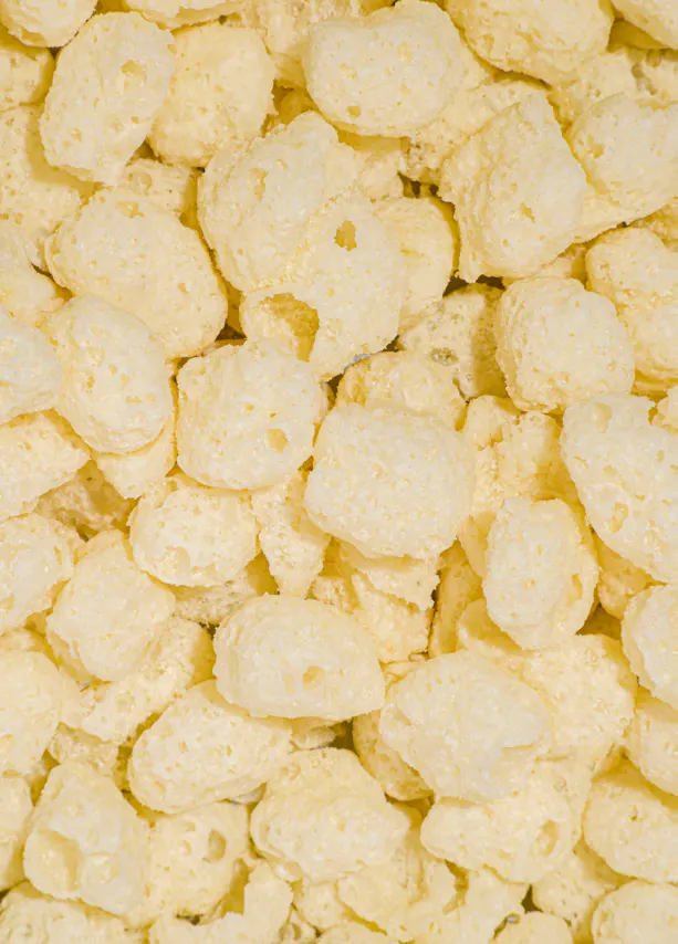 primo piano di cereali croccanti di mais di colore giallo chiaro dalla consistenza porosa.
