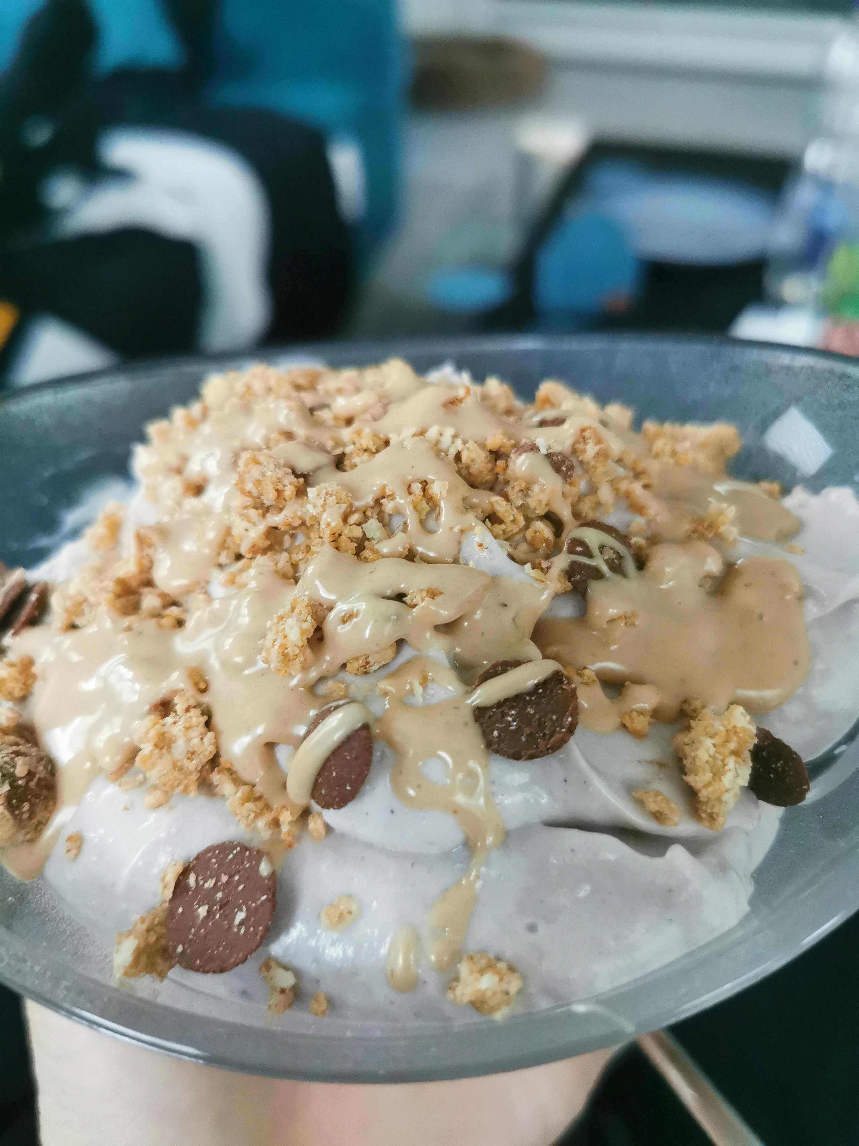 una persona tiene in mano un piatto di yogurt con granola e gocce di cioccolato