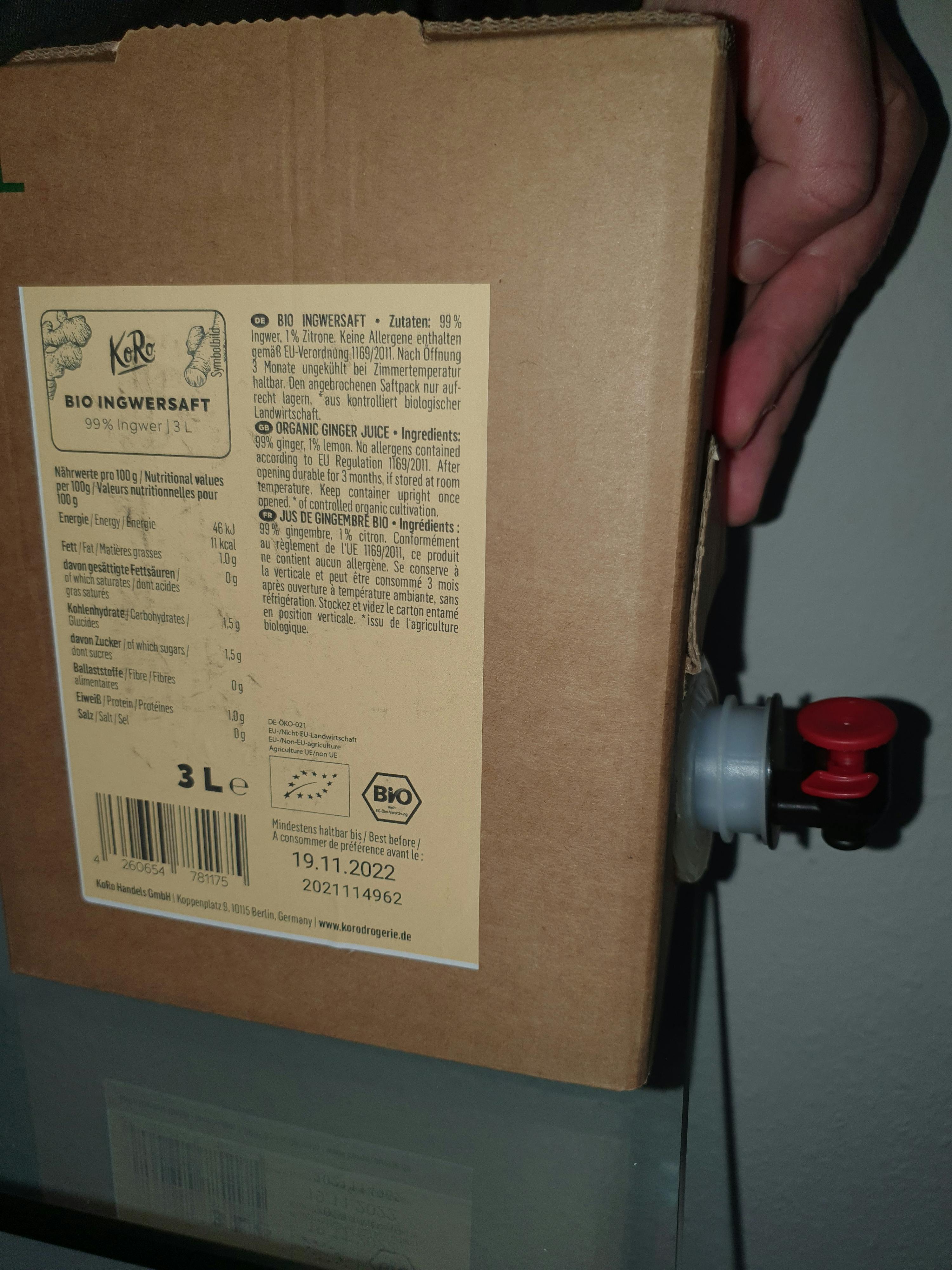 Eine Person hält einen Karton mit einem Etikett auf der Rückseite