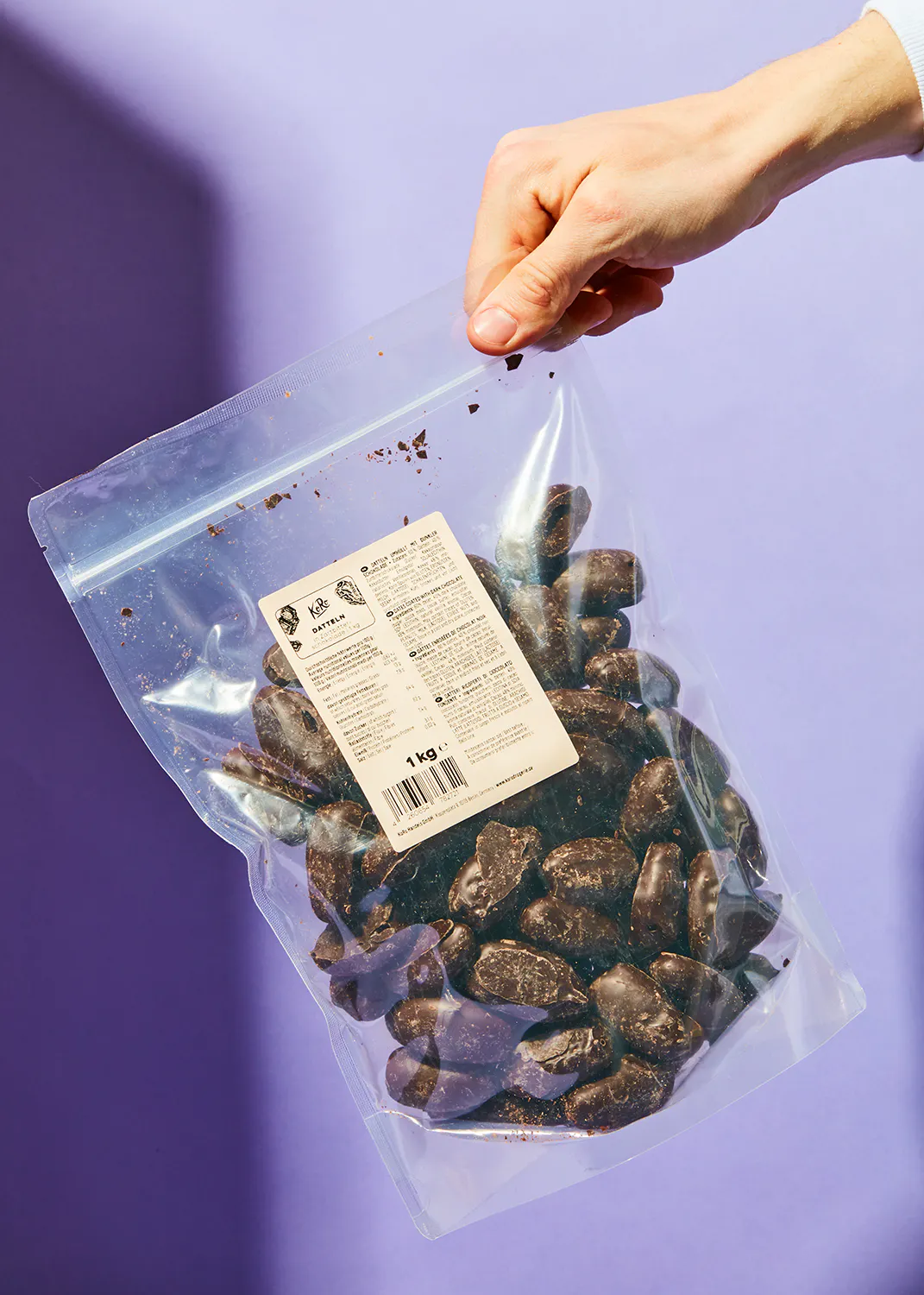 eine Person hält einen Plastikbeutel mit Schokoladenstücken in der Hand