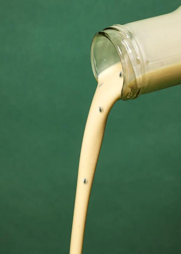 Milch wird aus einer Glasflasche gegossen