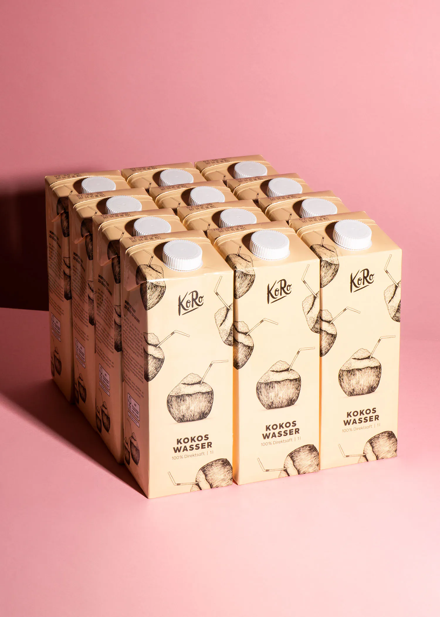 une pile de cartons d' eau de noix de coco sur fond rose