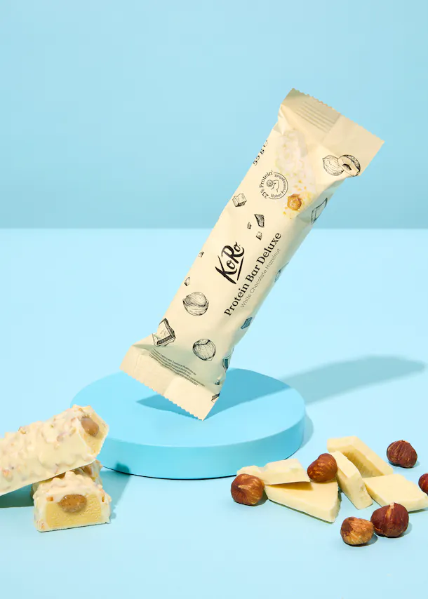 une barre de protéines blanche avec des noix sur une table bleue