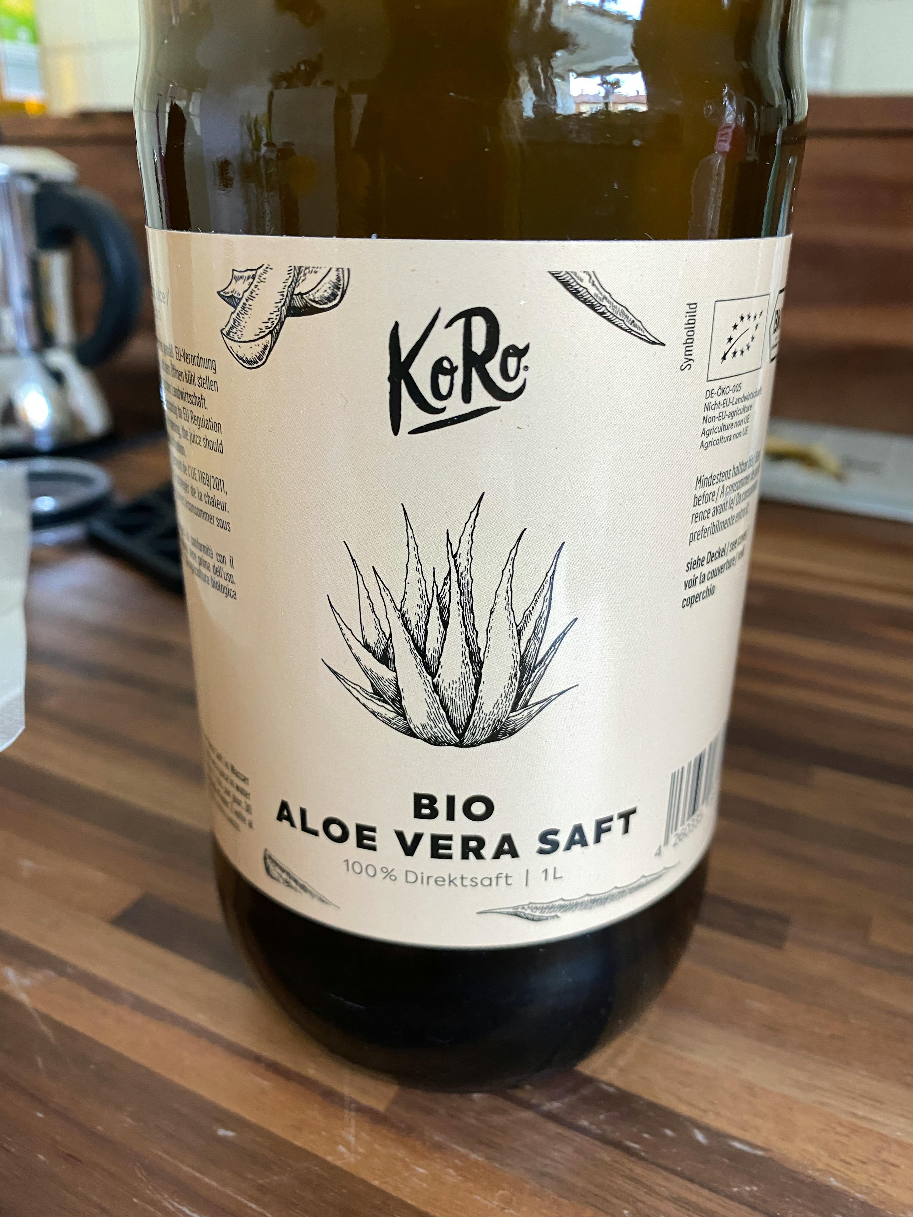 une bouteille d' aloe vera bio posée sur une table en bois