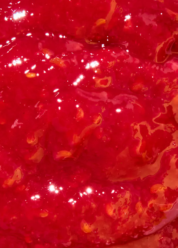 un gros plan d' un liquide rouge avec des gouttes d' orange