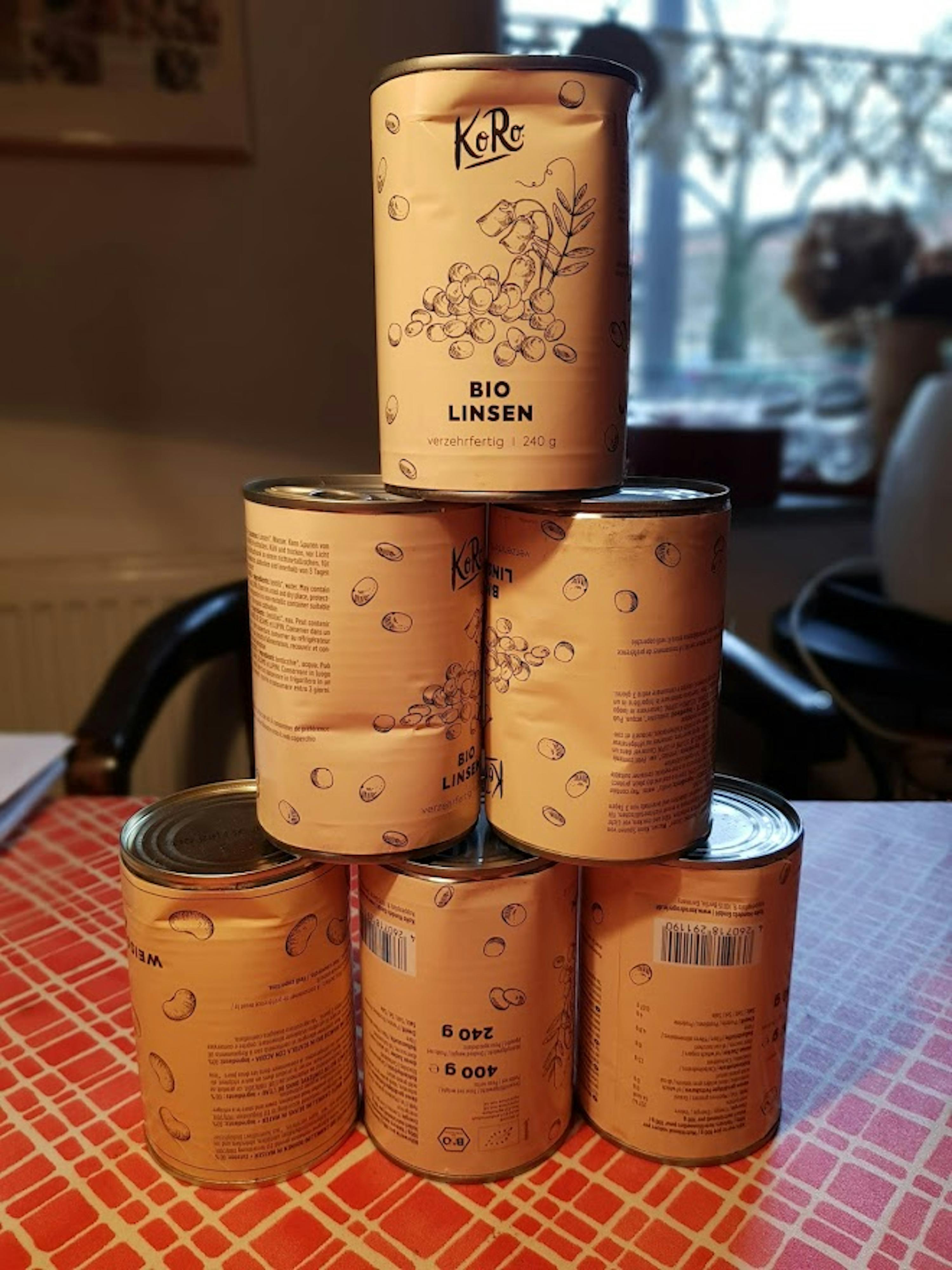 quattro lattine di cibo bio sono impilate su un tavolo