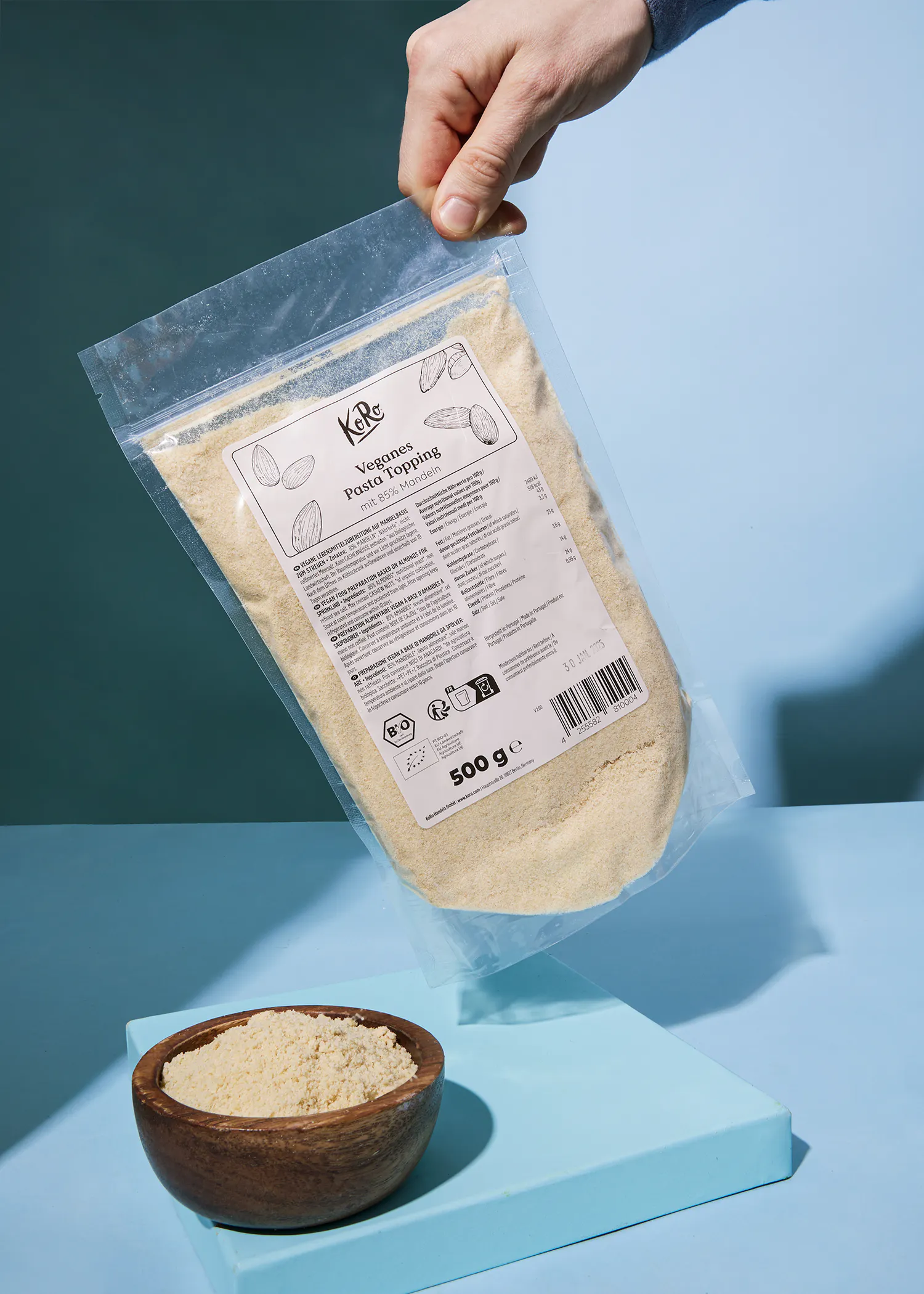 eine Person hält einen Plastikbeutel mit einem Etikett darauf und füllt ihn mit einem 500 g-Produkt