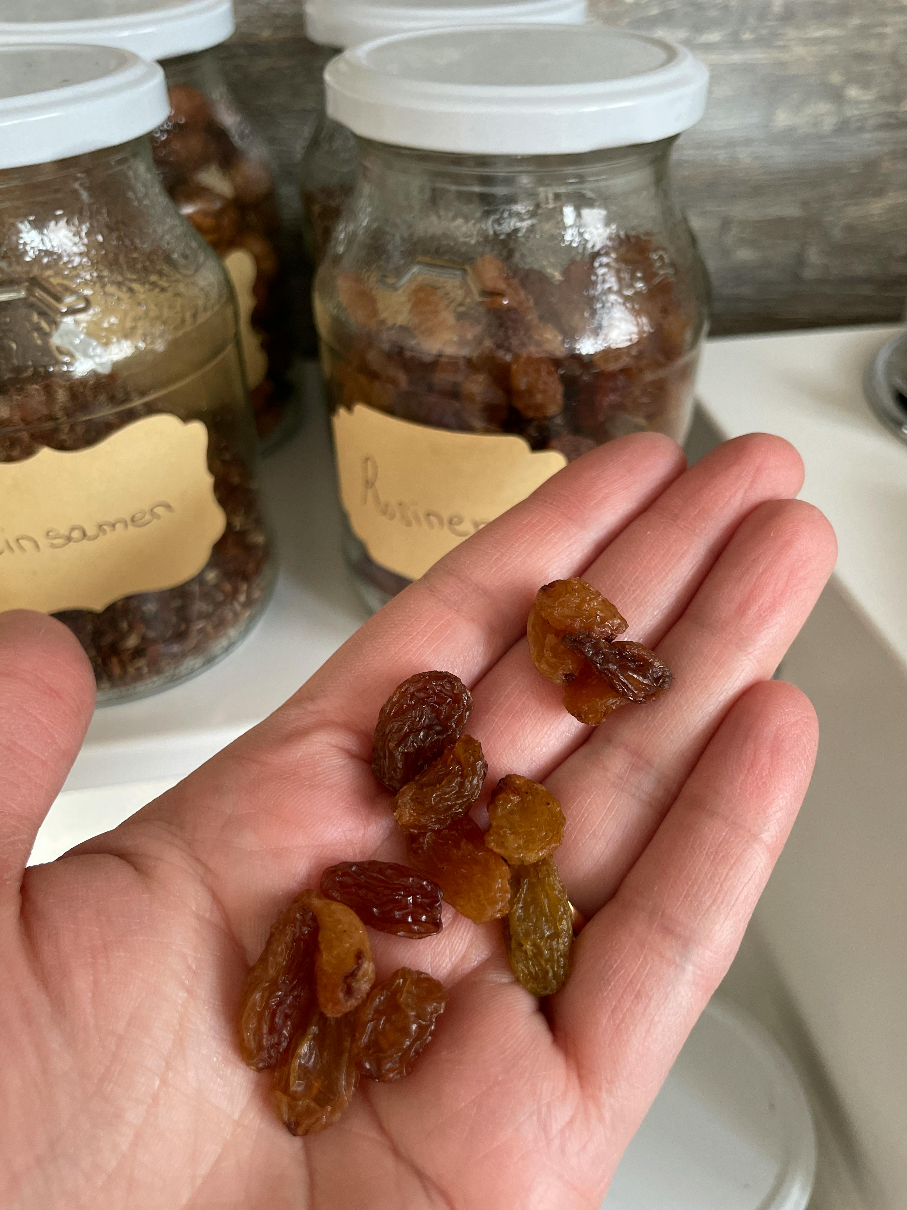 une personne tient des raisins dans sa main