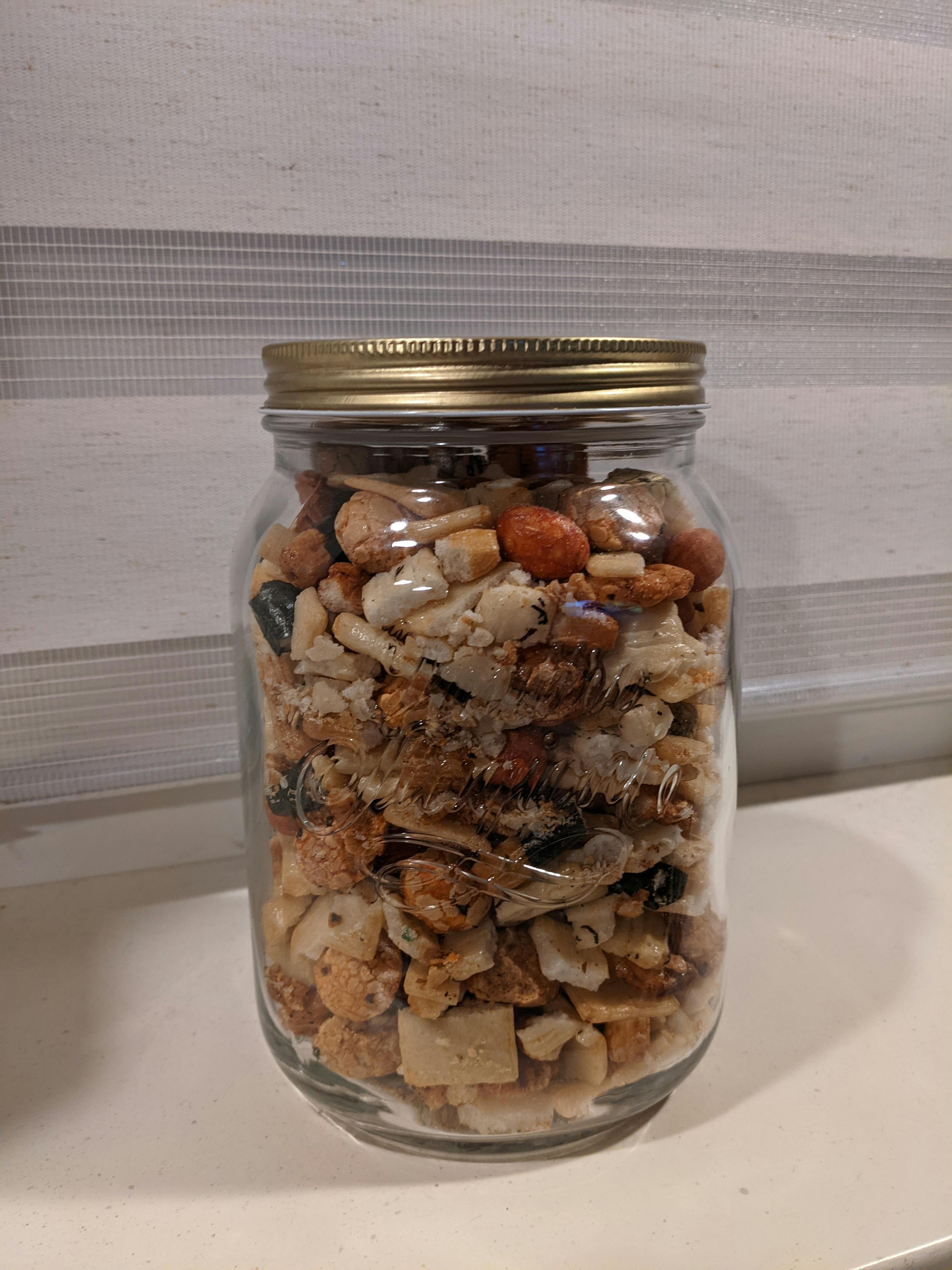 un bocal en verre rempli de nourriture avec un couvercle doré