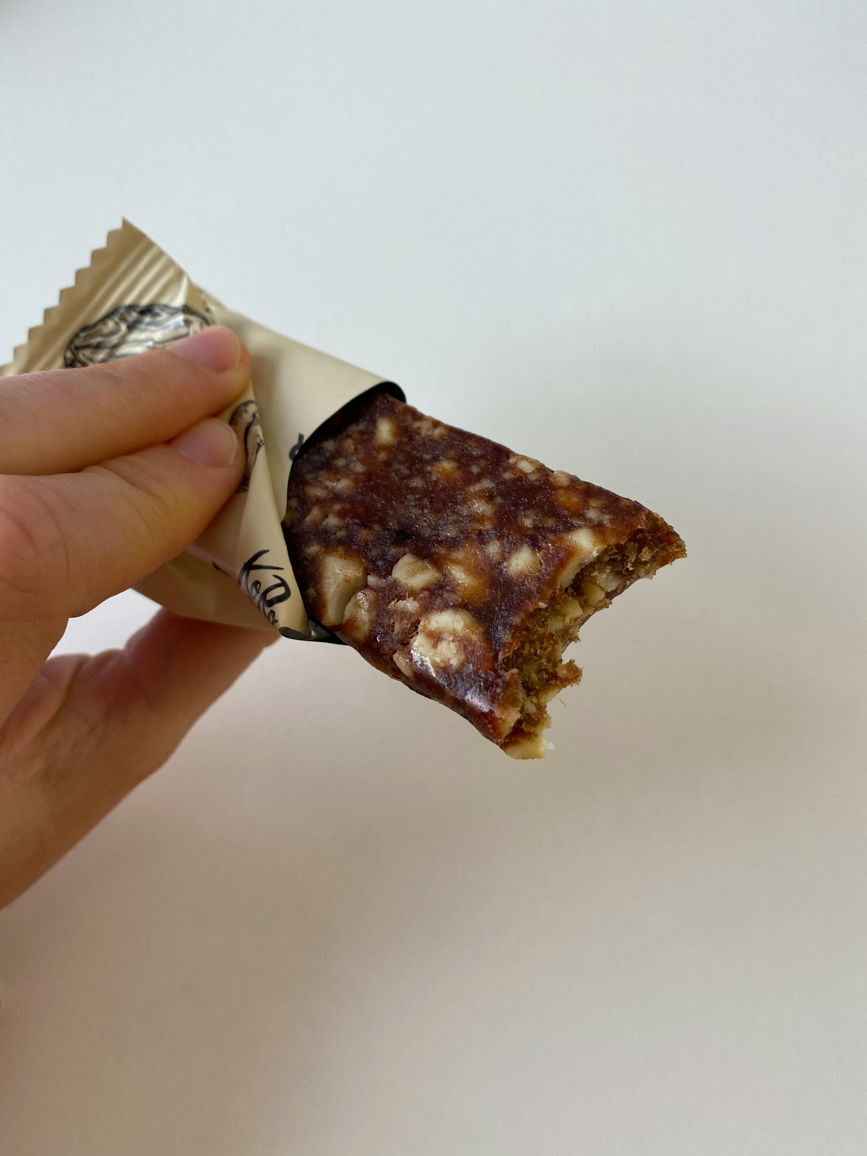 una persona tiene in mano una barretta di cioccolato con una fetta rotta