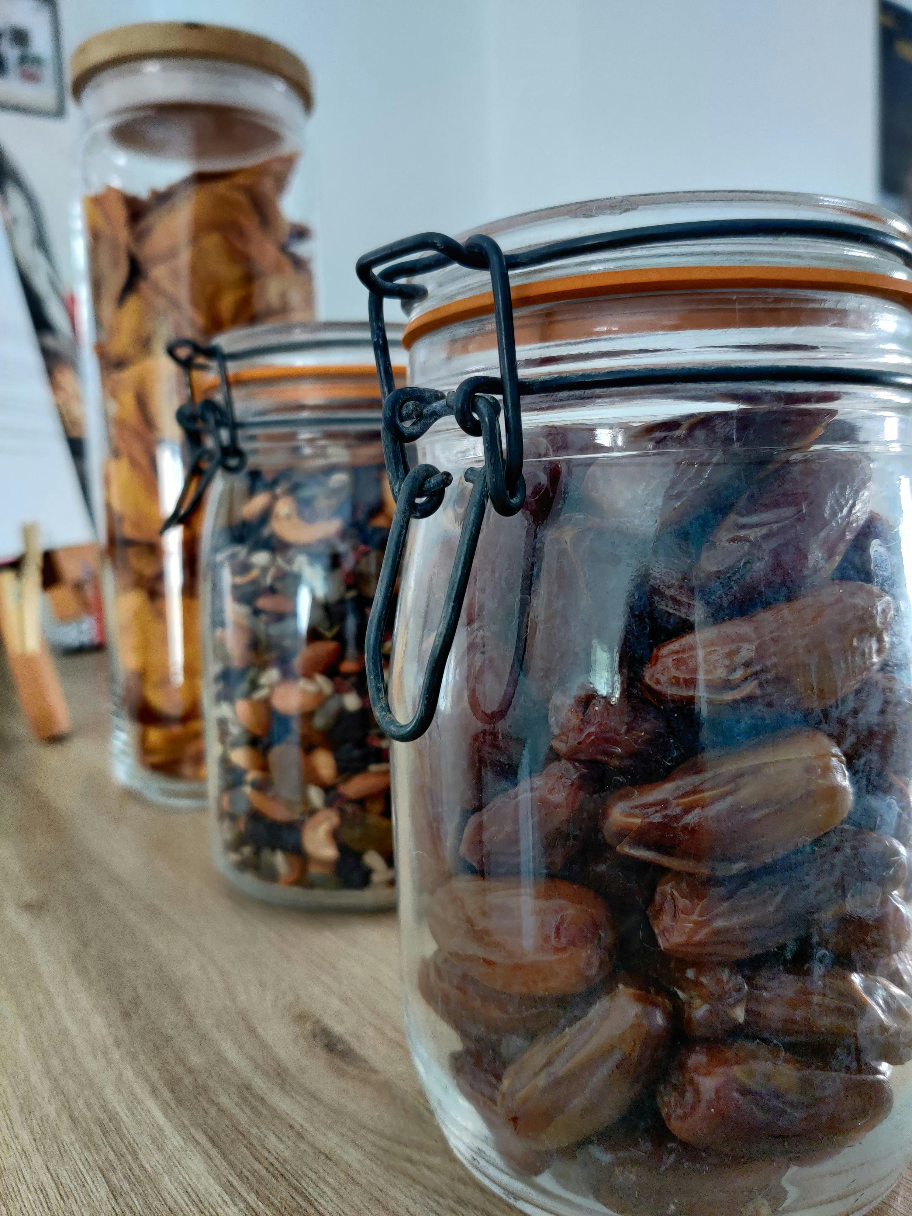 eine Reihe von Gläsern mit verschiedenen Früchten und Nüssen