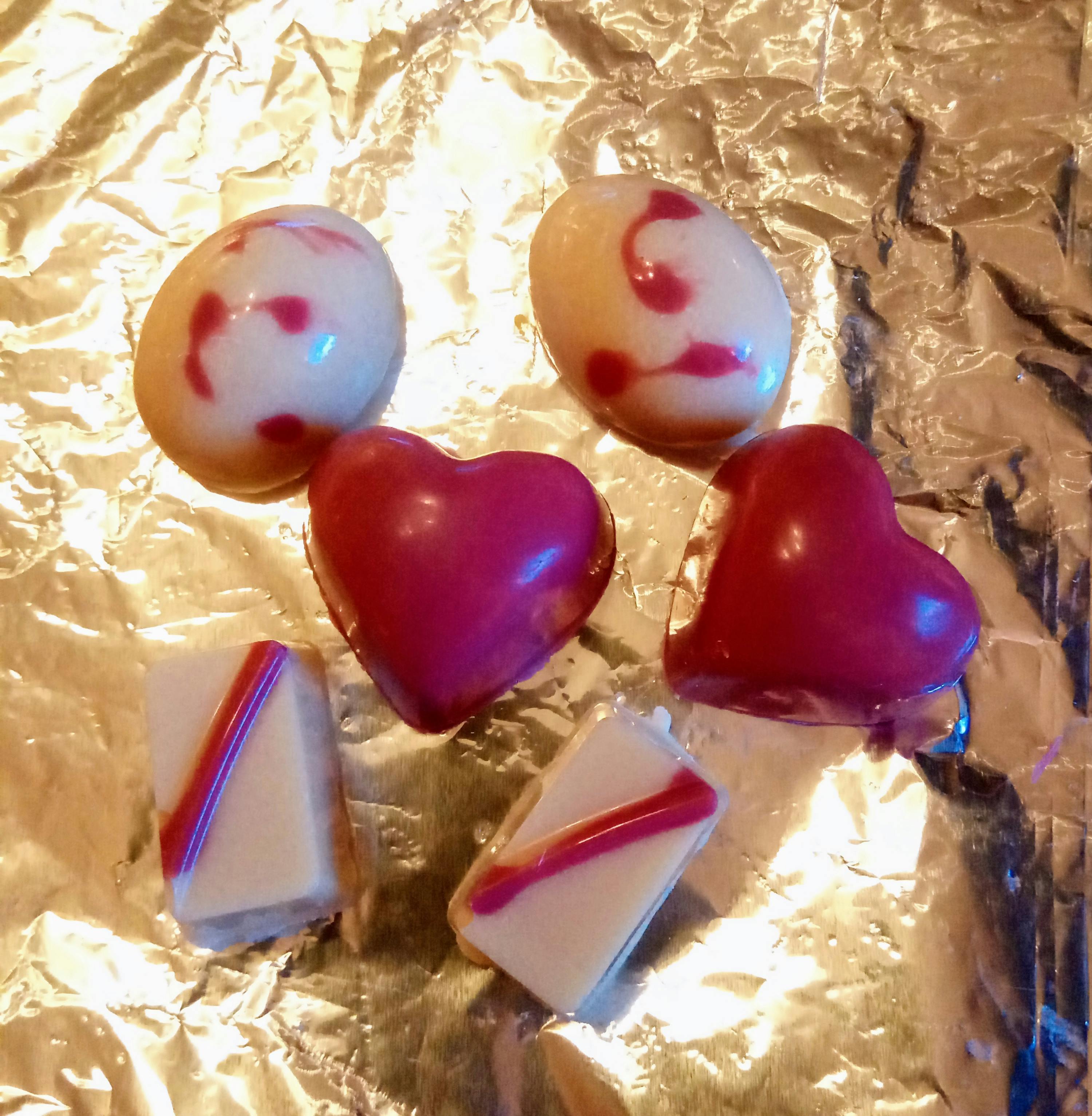 eine Gruppe von Schokoladen mit roten und weißen Herzen darauf