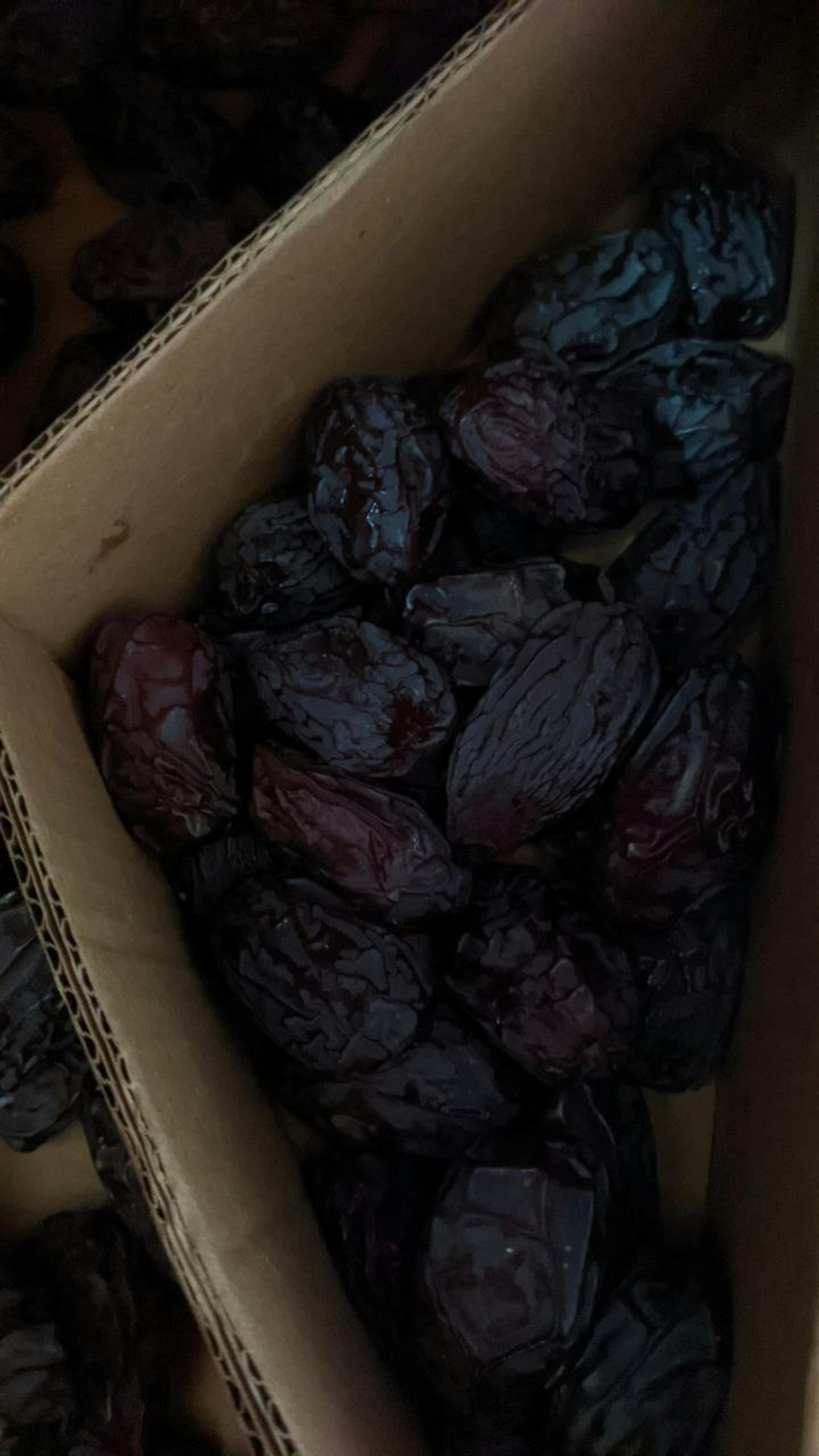 a cardboard box filled with a lot of black dates