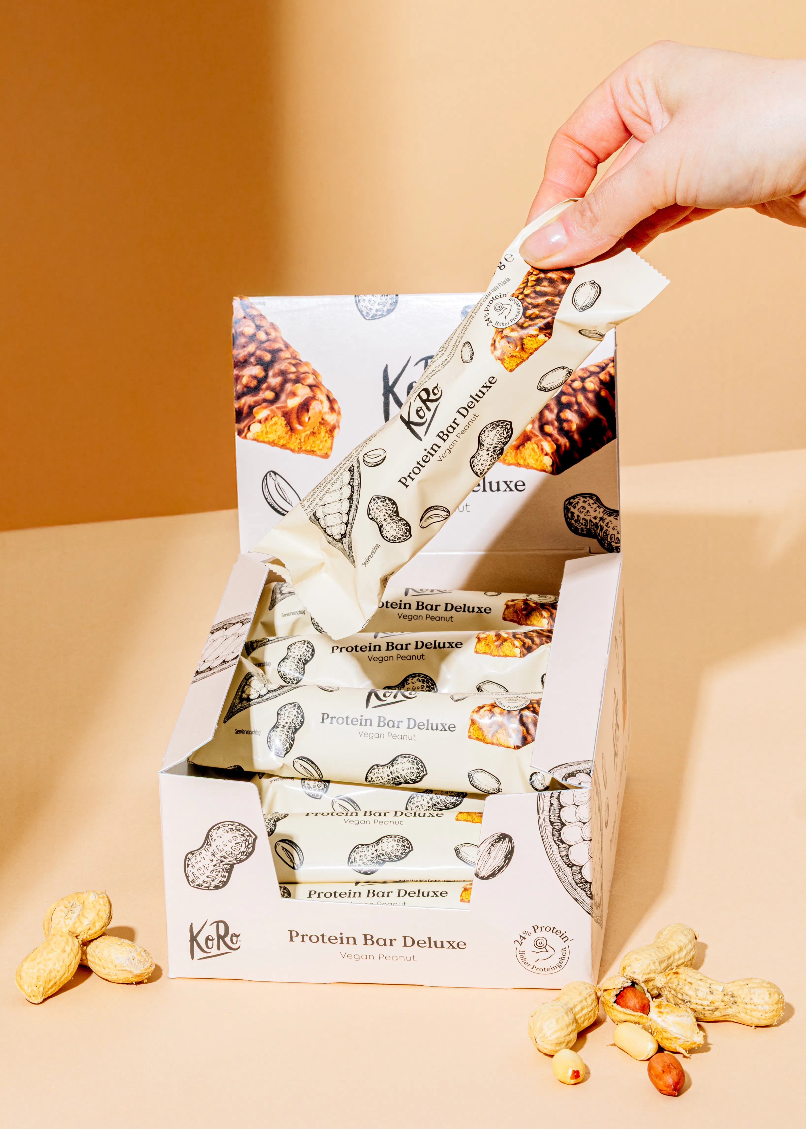 eine Person nimmt einen protein-bar deluxe aus einer box