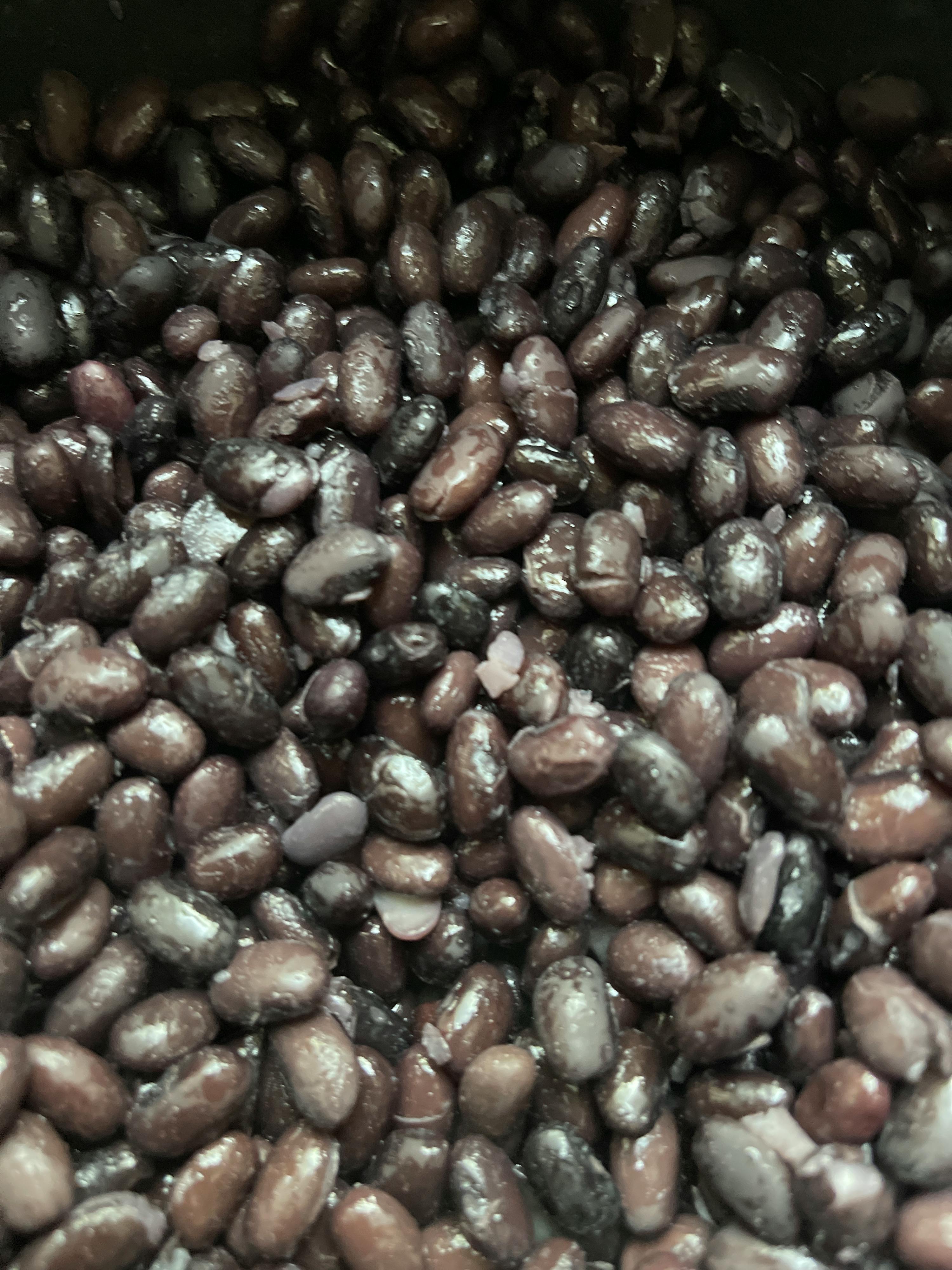 eine Nahaufnahme von schwarzen Bohnen in einem Topf