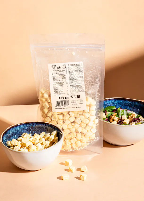 eine Schüssel mit einem Salat neben einem Plastikbeutel mit einem Etikett auf der Rückseite