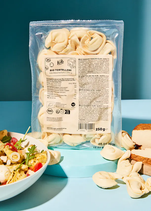 un sac de pâtes bio tortellon est posé sur une table bleue
