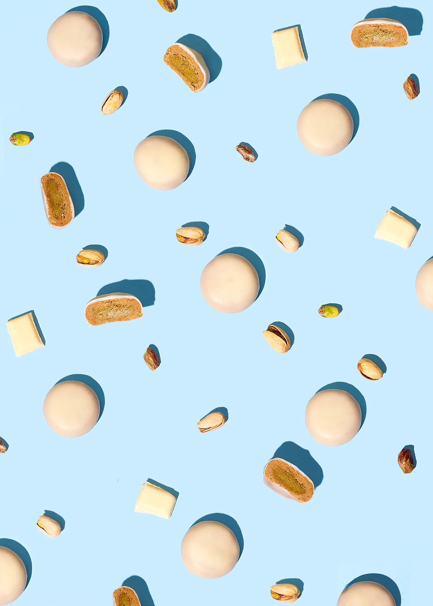 un motif de pistaches et de biscuits blancs sur fond bleu