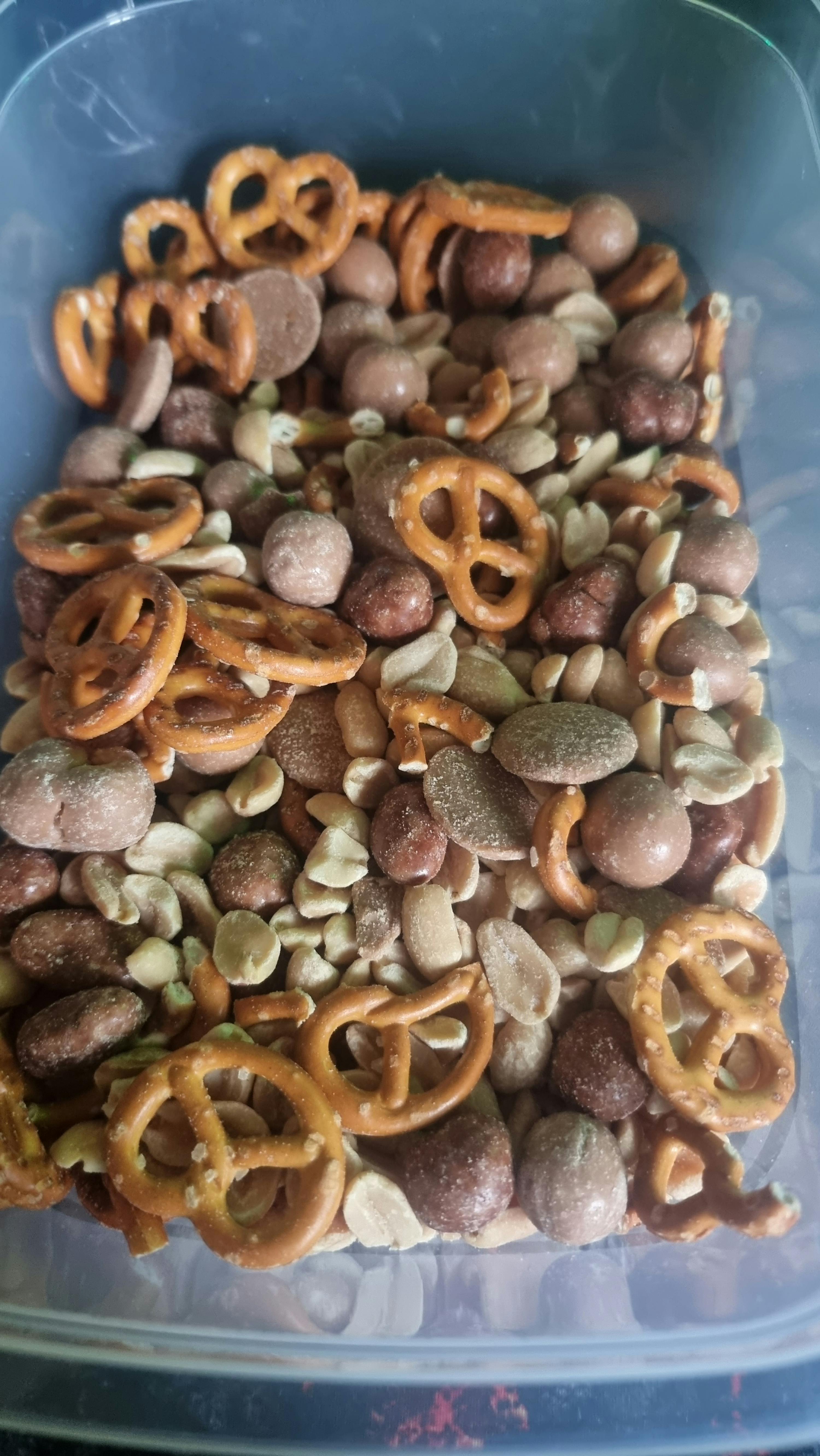 un tas de noix et de bretzels dans une boîte en plastique