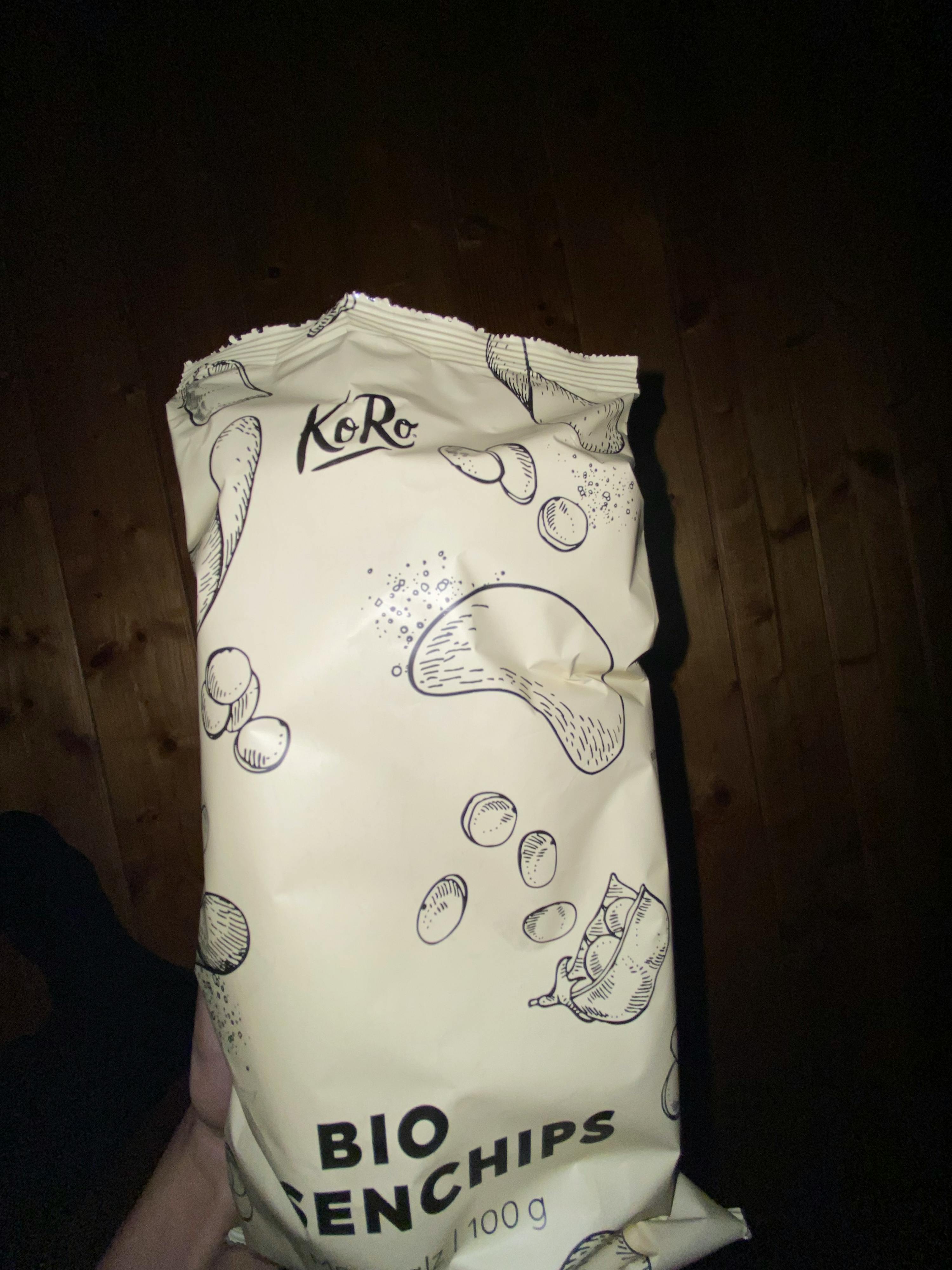 eine Person hält eine Tüte Kartoffelchips in der Hand