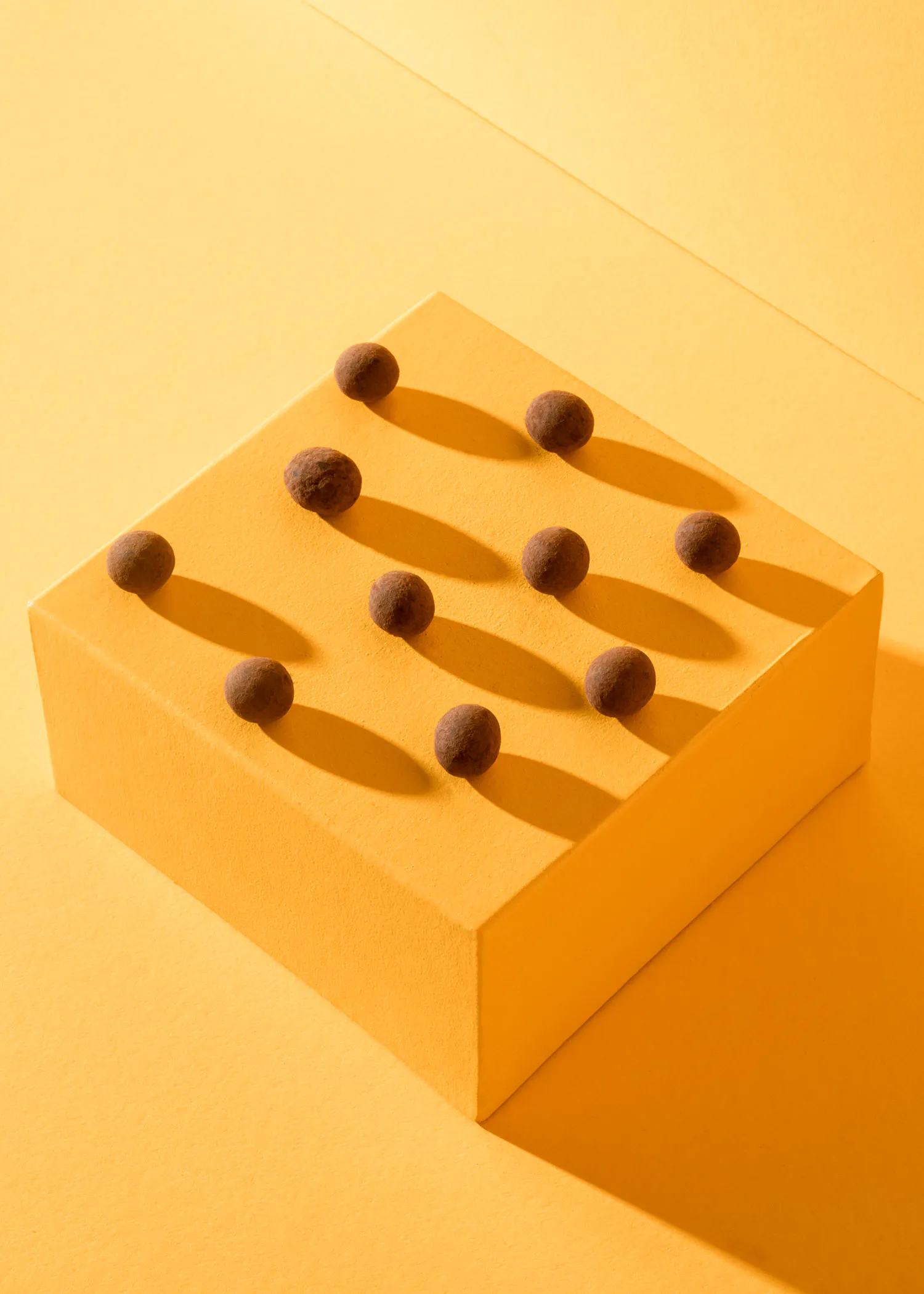 un carré jaune avec des boules de chocolat sur le dessus