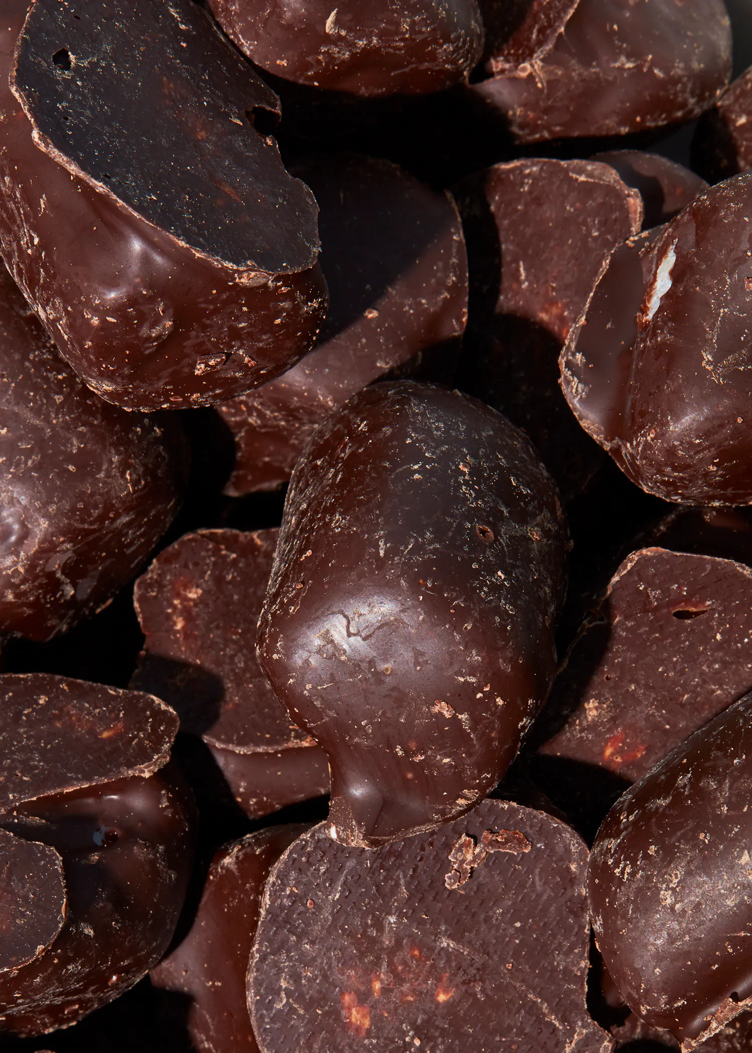 ein Haufen dunkler Schokolade mit einem gebrochenen Stück darauf