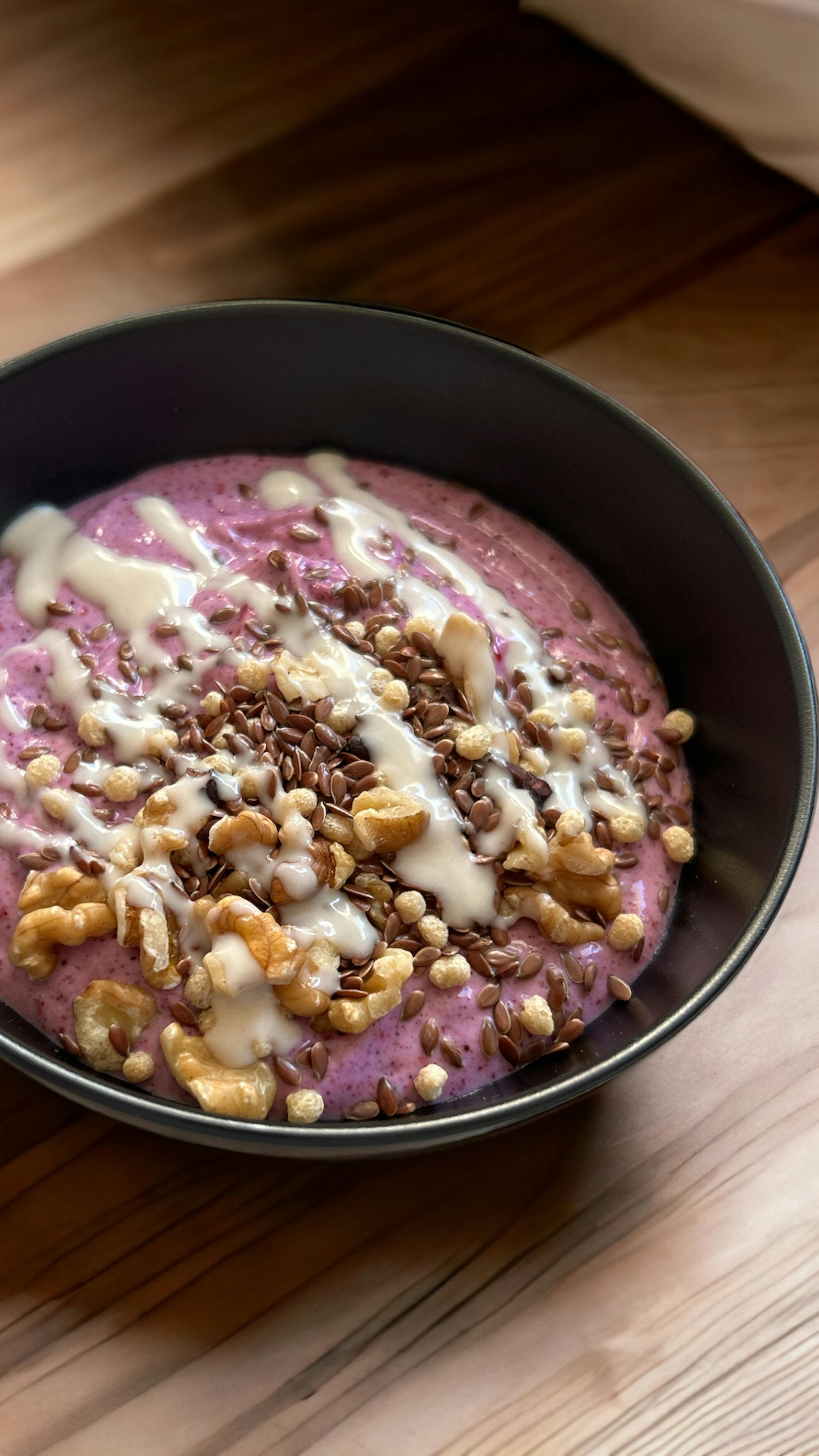 una ciotola di yogurt con noci e semi di lino su un tavolo di legno