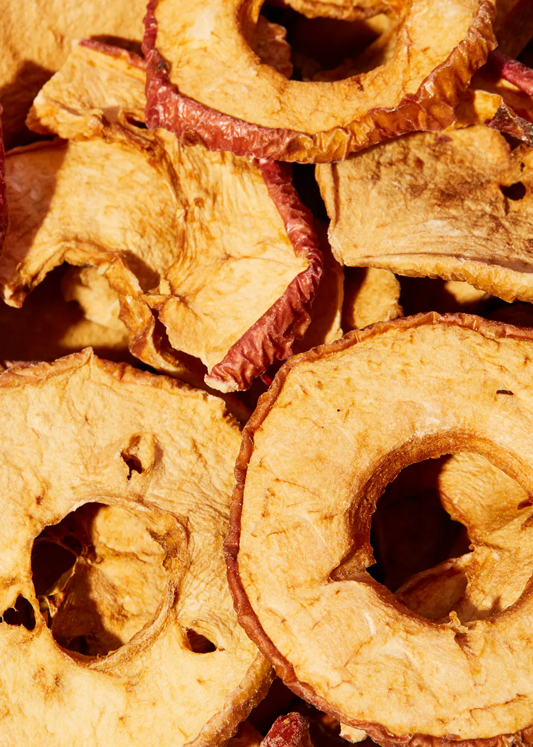 a pile of dried apple slices with holes in them