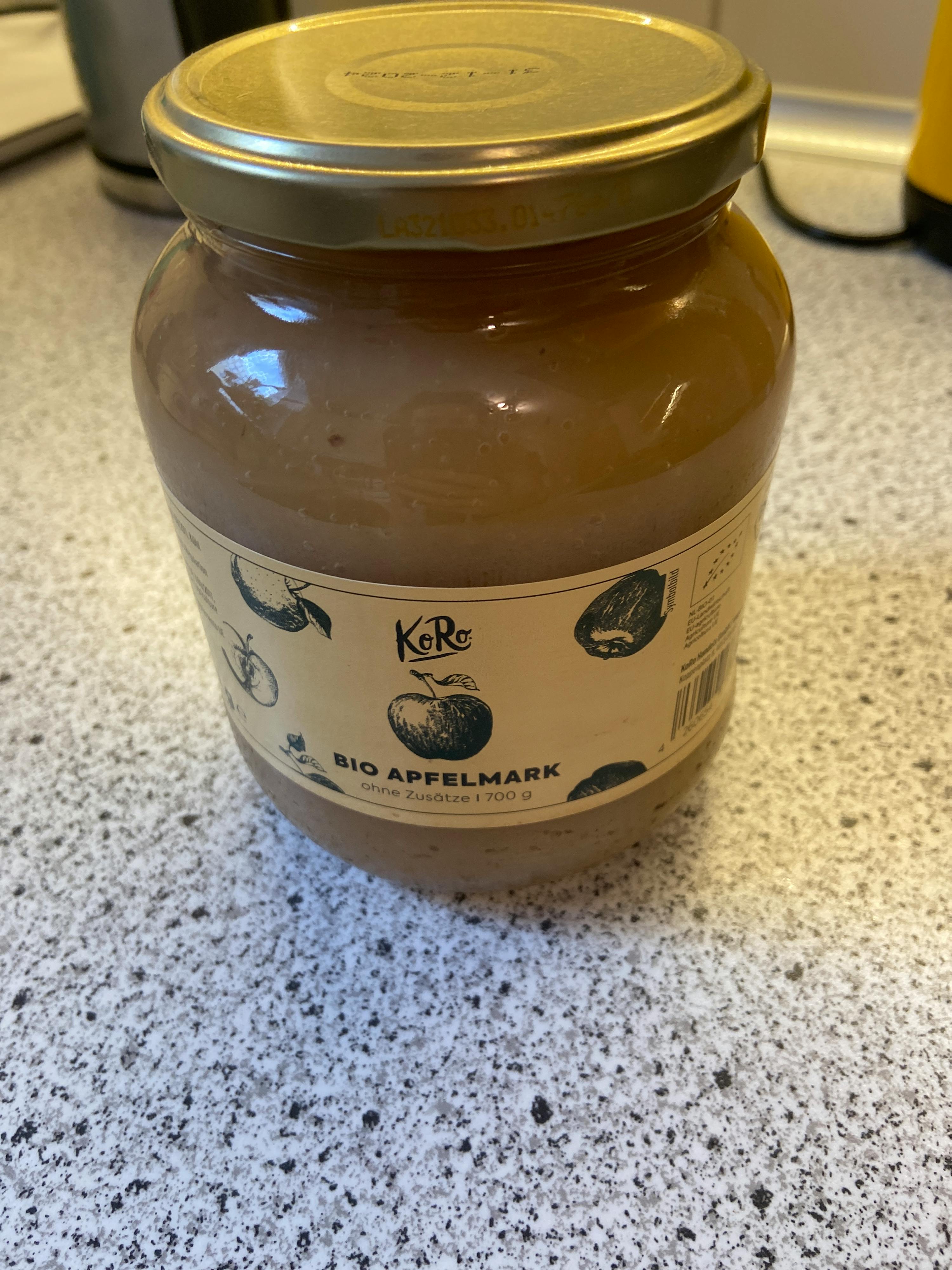 un barattolo di marmellata di mele è seduto su un tavolo