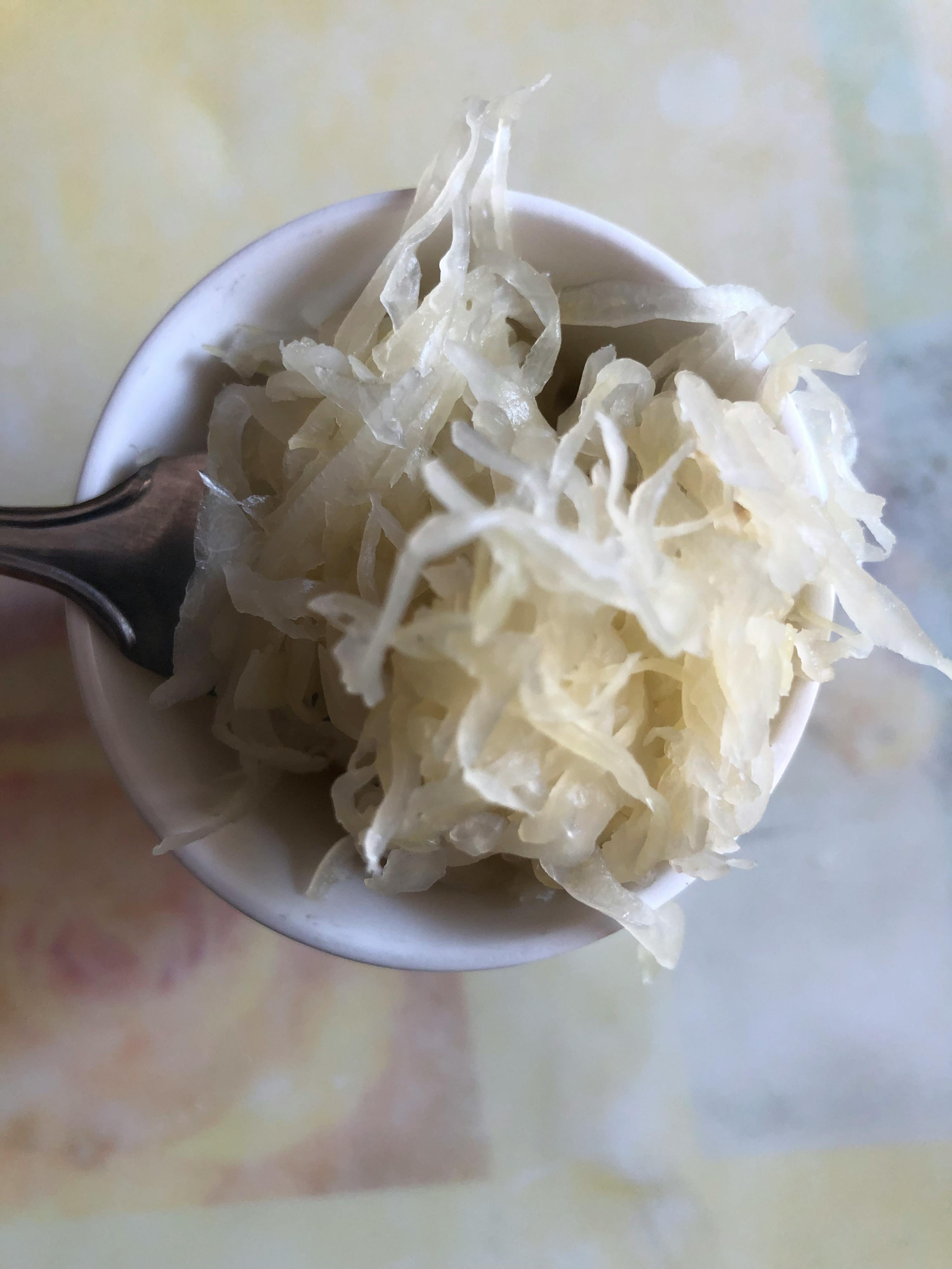 a bowl of shredded cabbage with a spoon in it