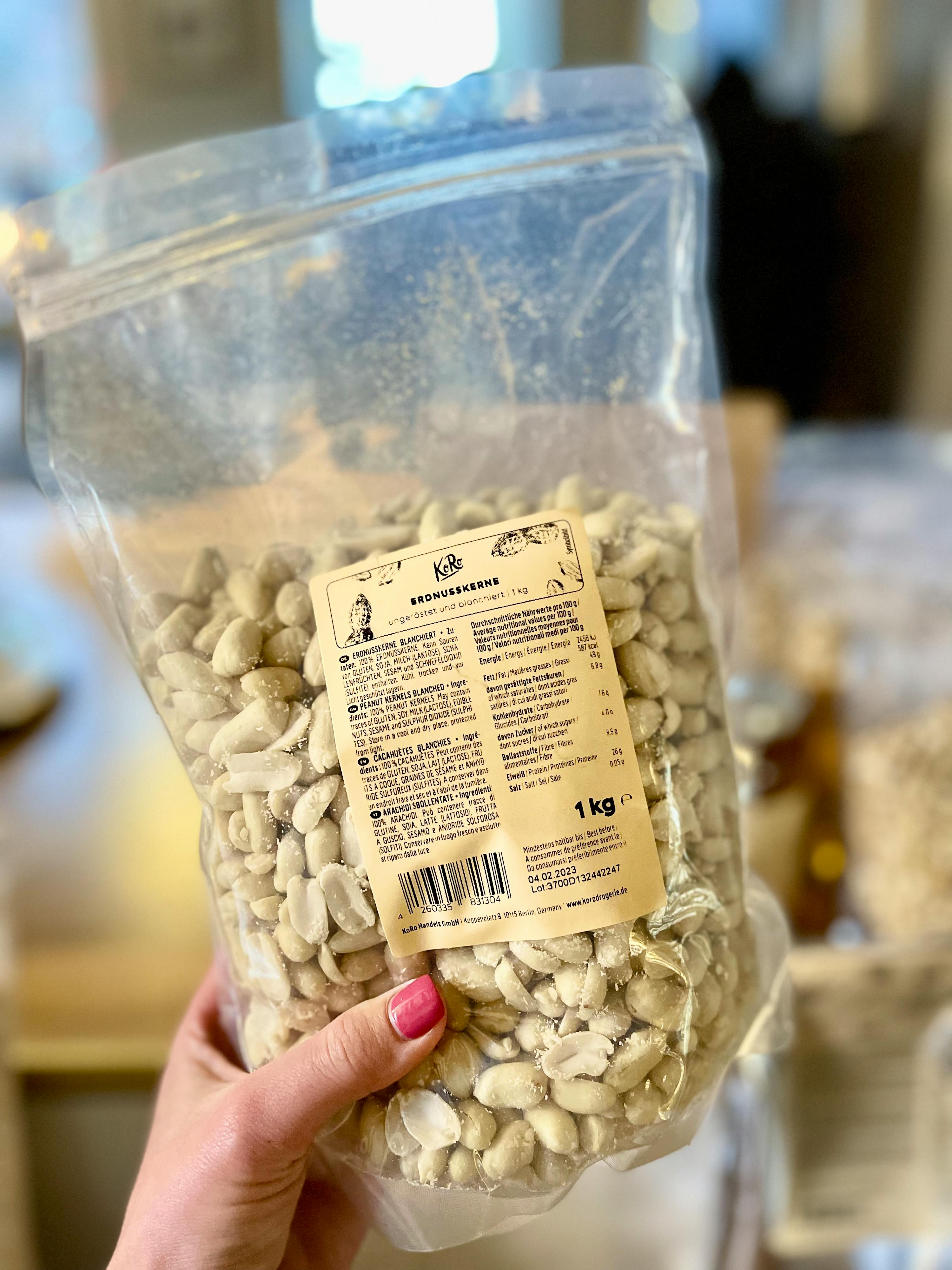 Eine Person hält einen Plastikbeutel mit weißen Bohnen in der Hand