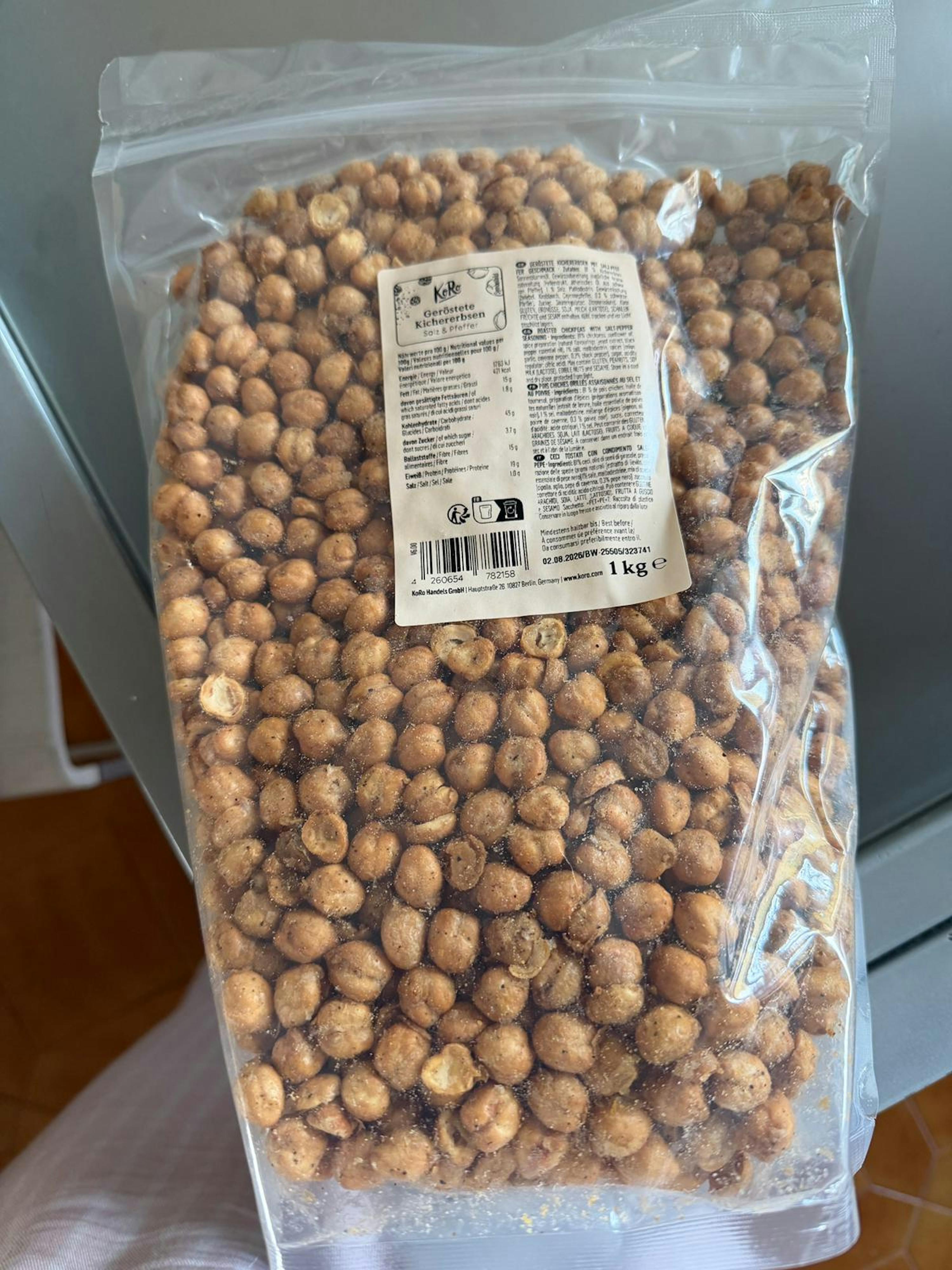 a clear plastic bag filled with 1 kg of roasted chickpeas seasoned with salt and pepper.
