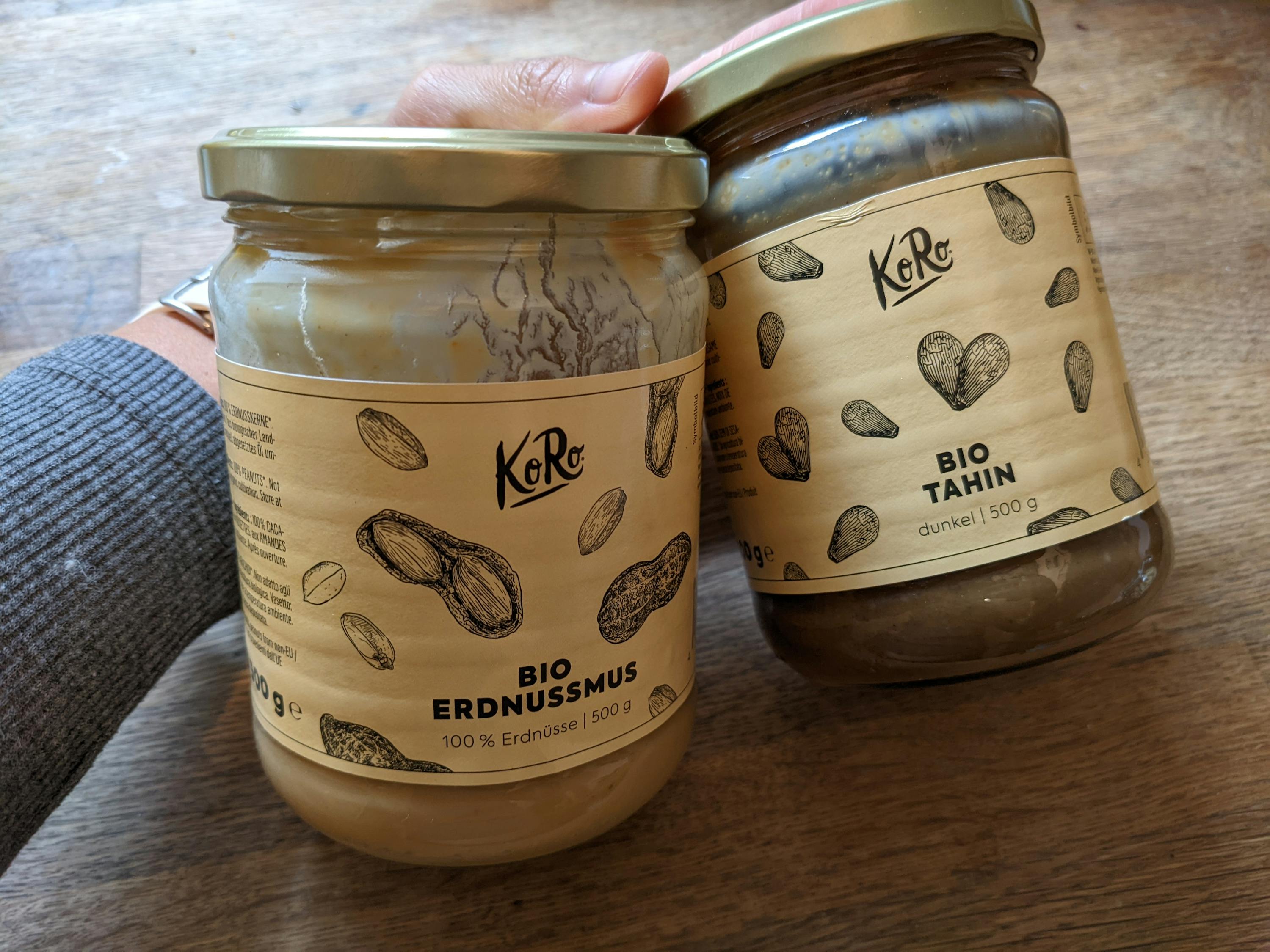 a jar of bio erdnussmus and a jar of bio tahin