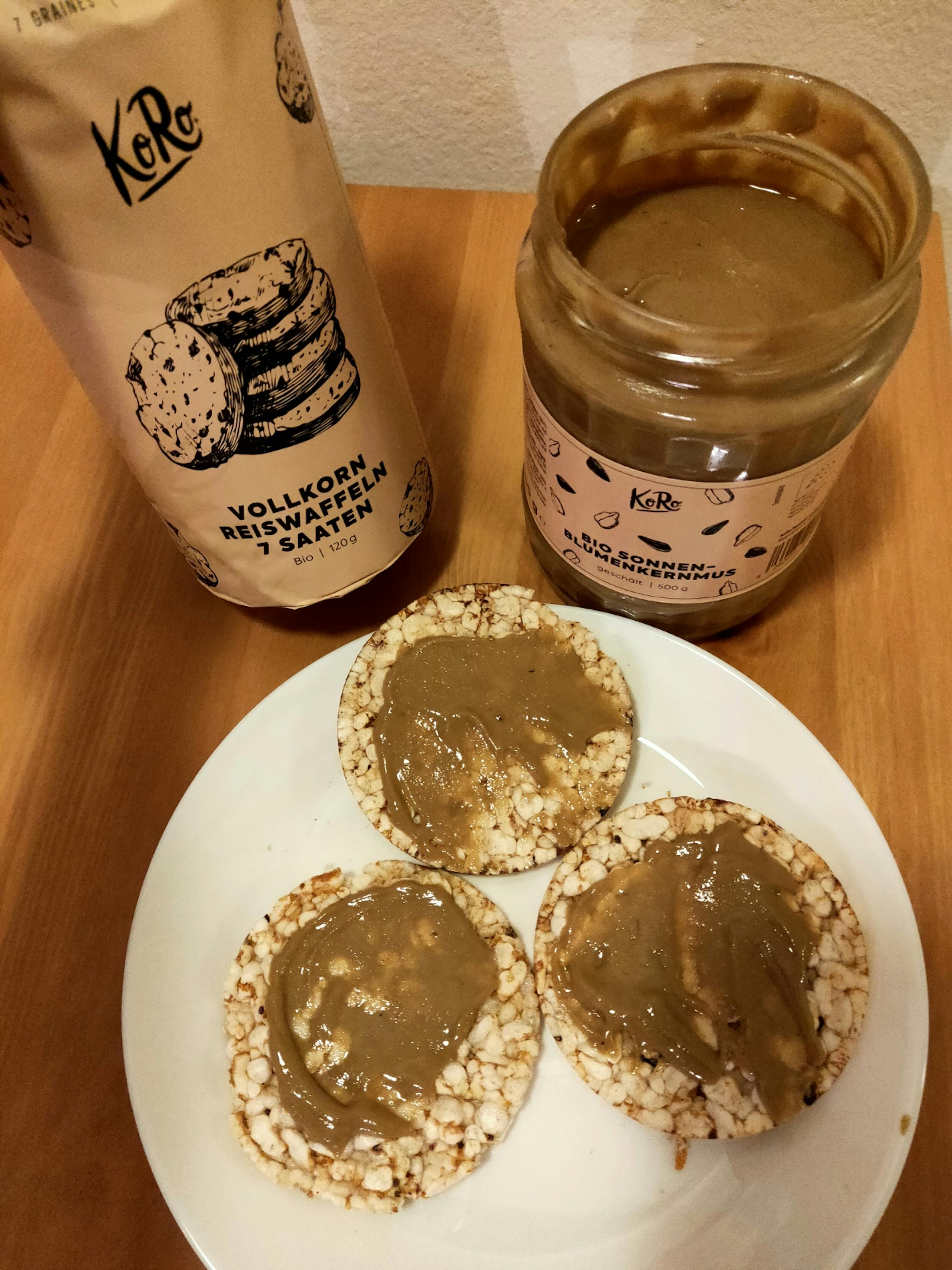 eine Flasche vollkornreiswaffeln kratern steht neben einem Teller mit drei Reiswaffeln mit Erdnussbutter darauf