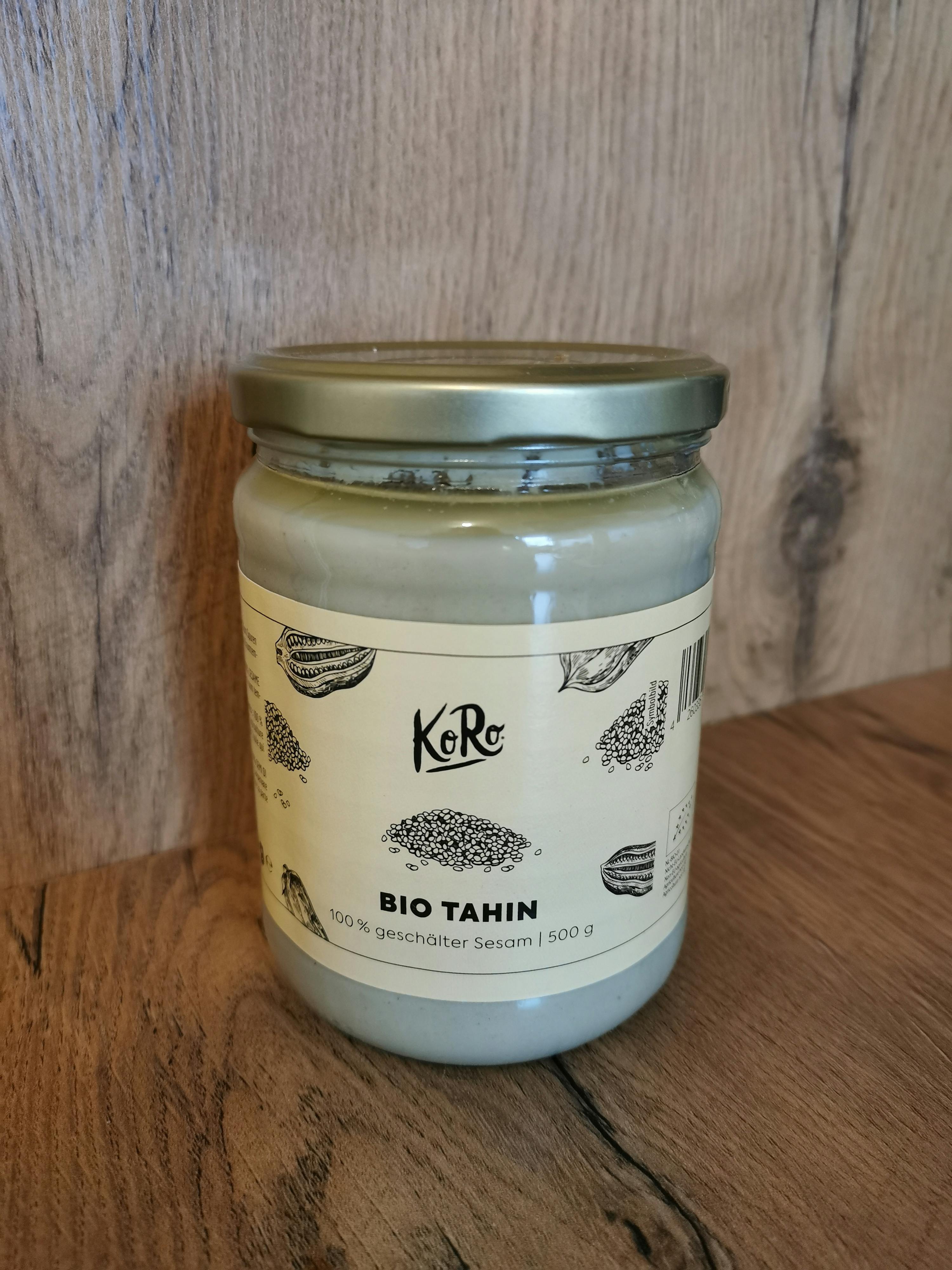 ein Glas bio Tahin liegt auf einem Holztisch