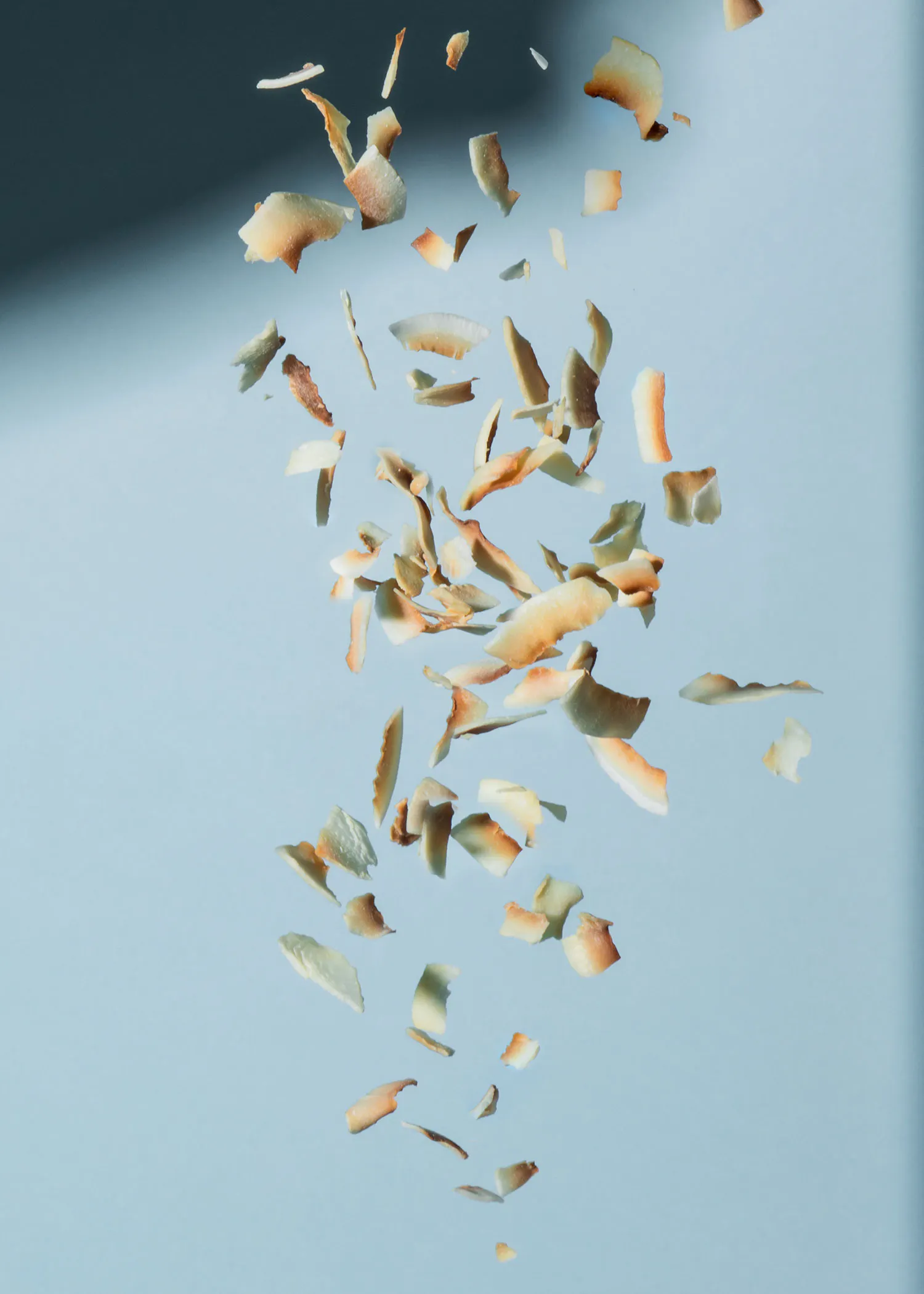 pieces of coconut falling in the air on a blue background