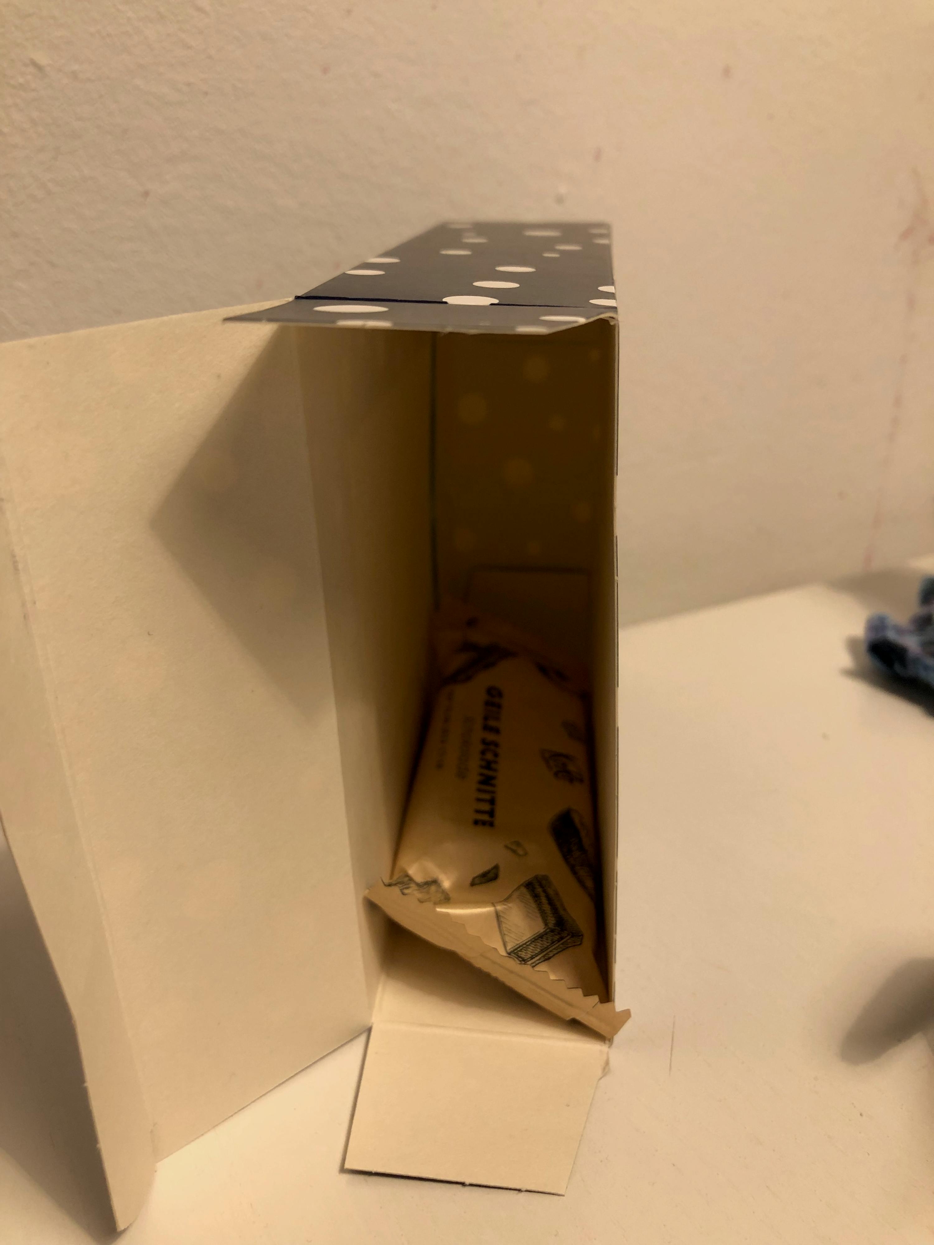 una piccola scatola con sopra una barretta di grana grattugiata