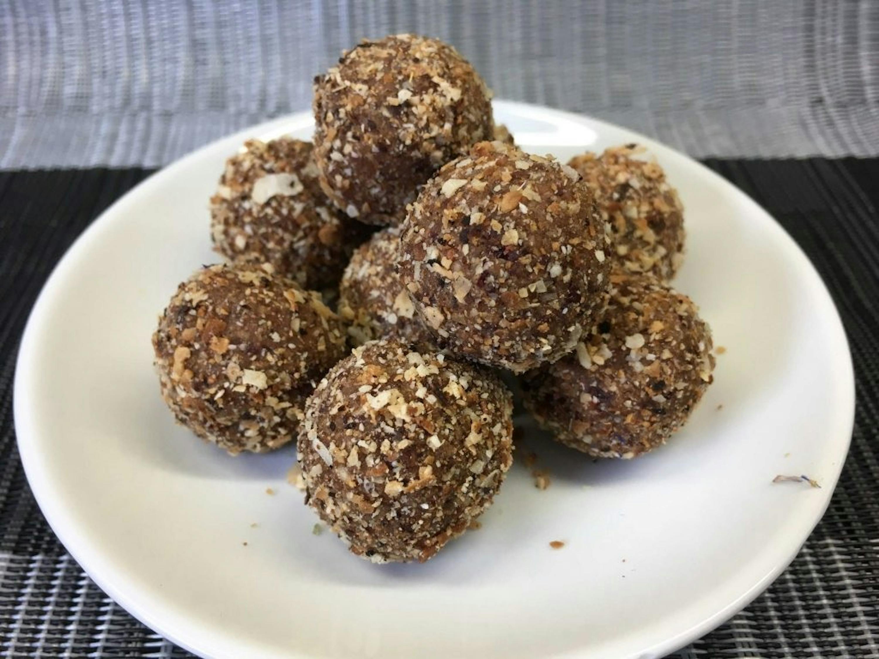 un gros plan d' une assiette blanche remplie de boules de nougat