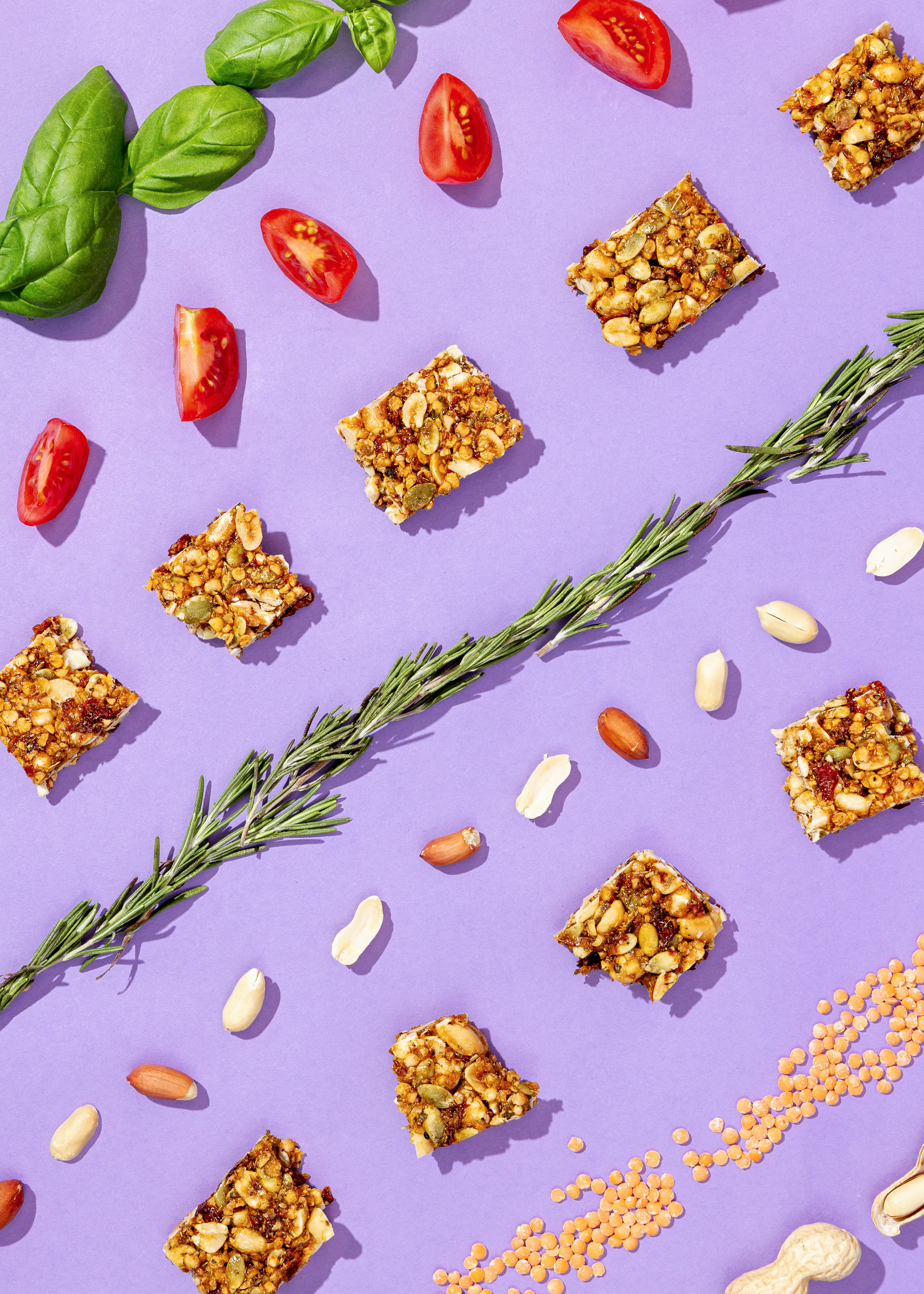 un motif de nourriture sur fond violet avec des tomates des noix et du romarin