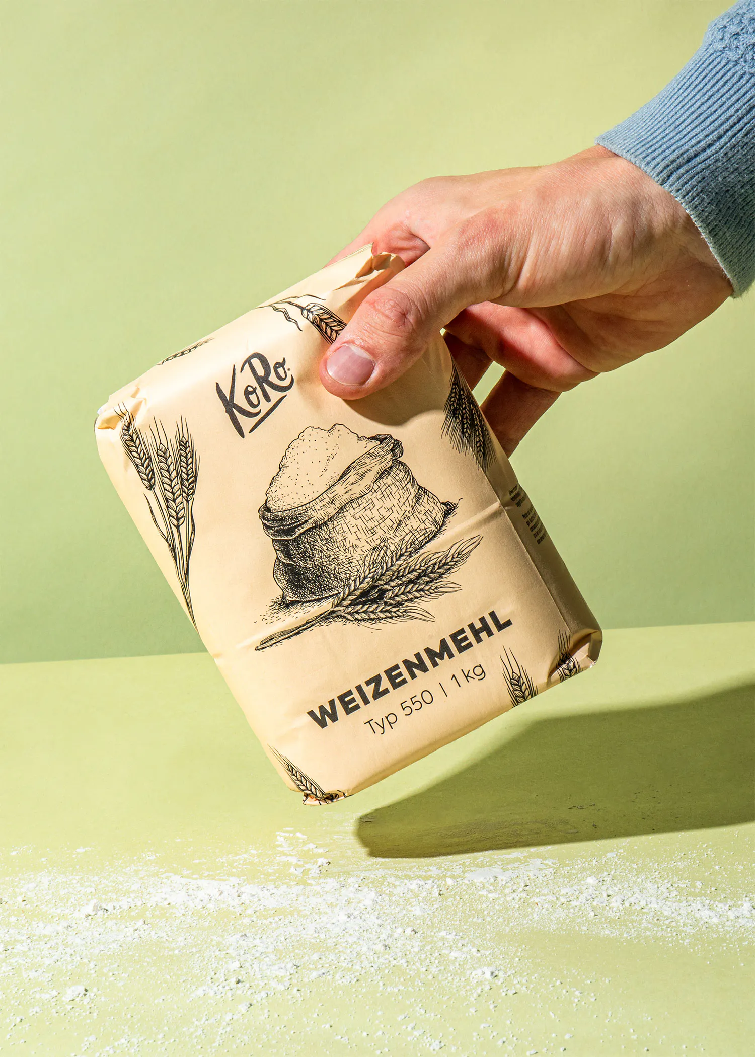 une personne tient un sac de farine de blé type 550 1 kg