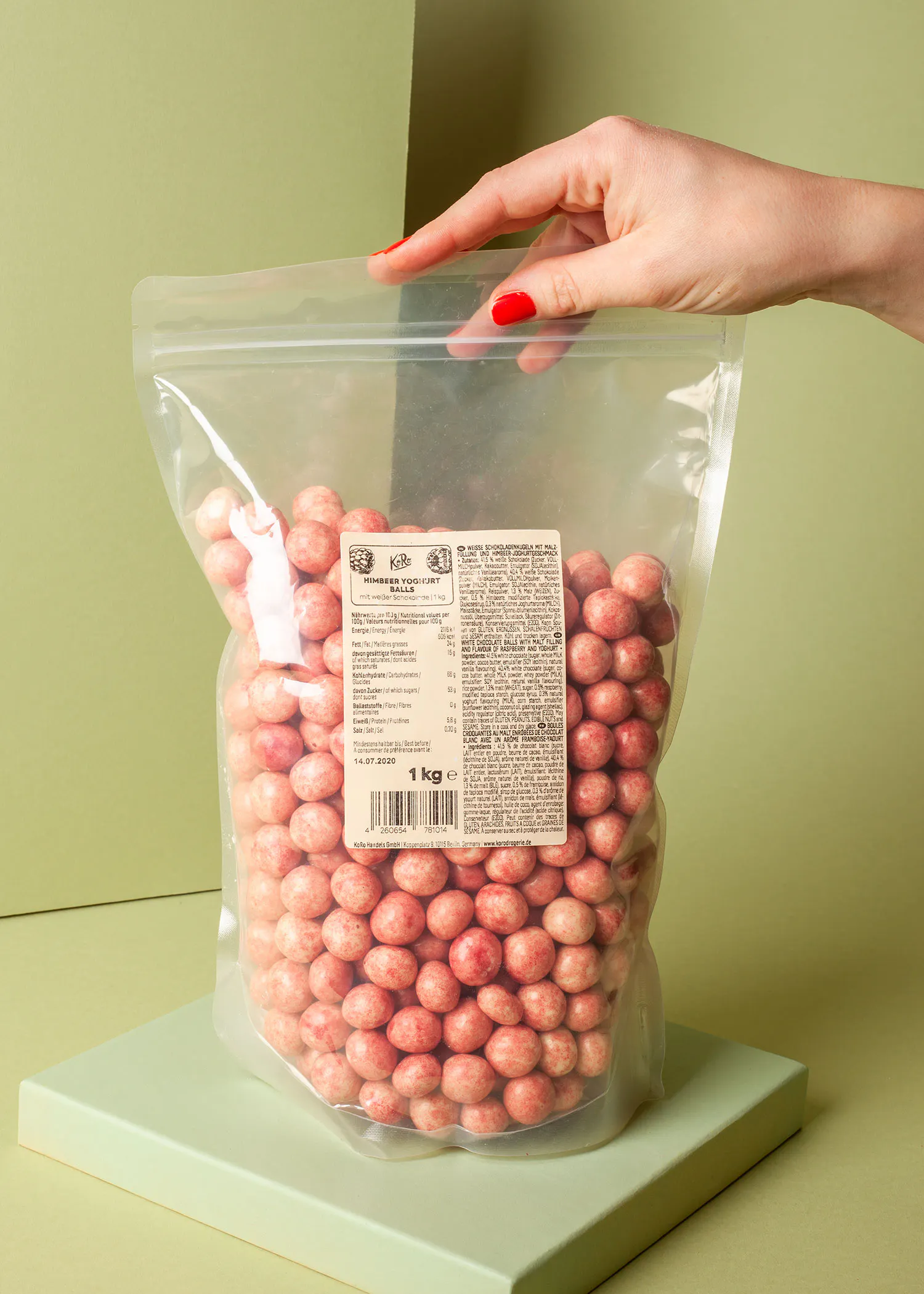 a woman is holding a bag of strawberry chocolate covered peanuts