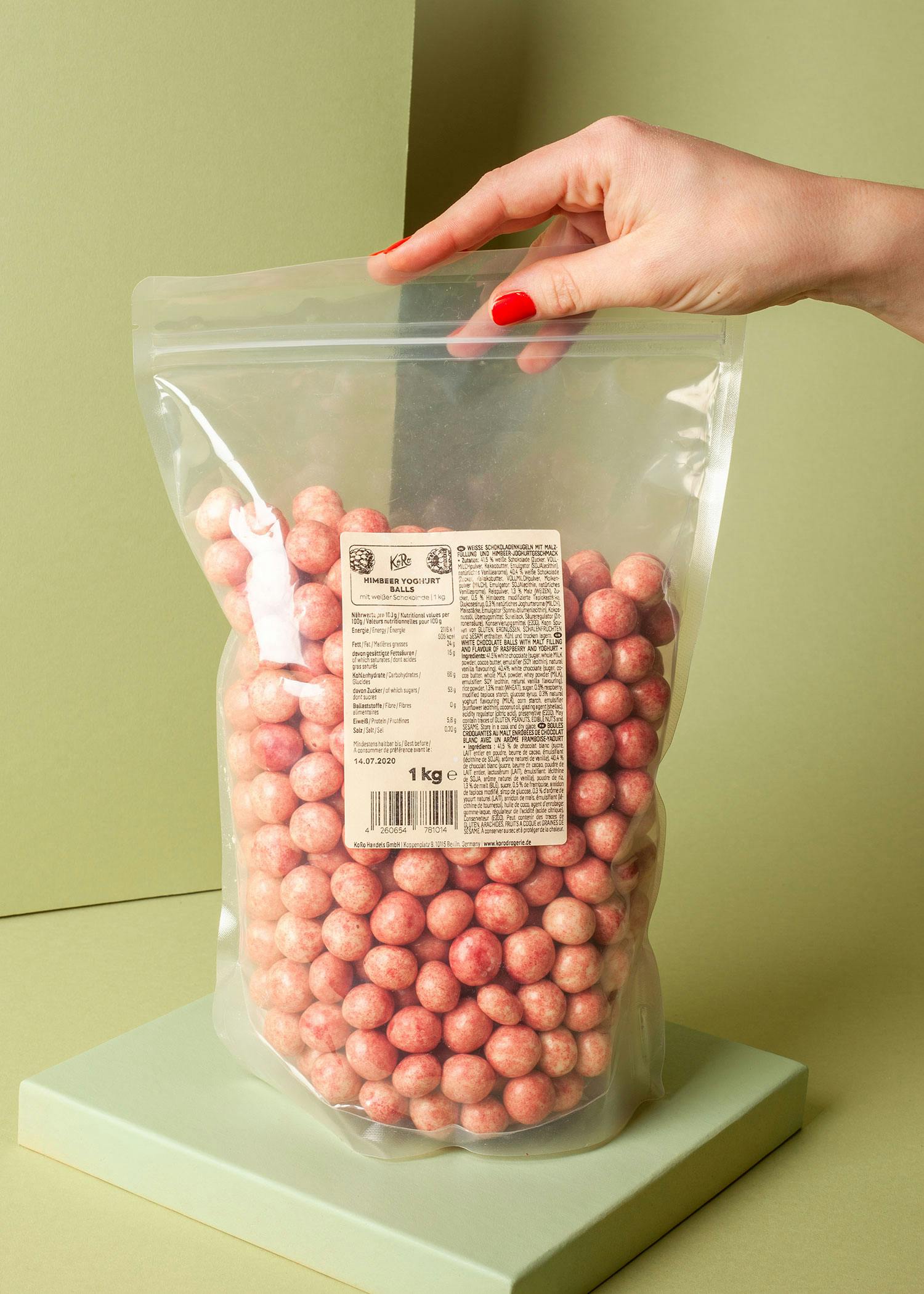 a woman is holding a bag of strawberry chocolate covered peanuts