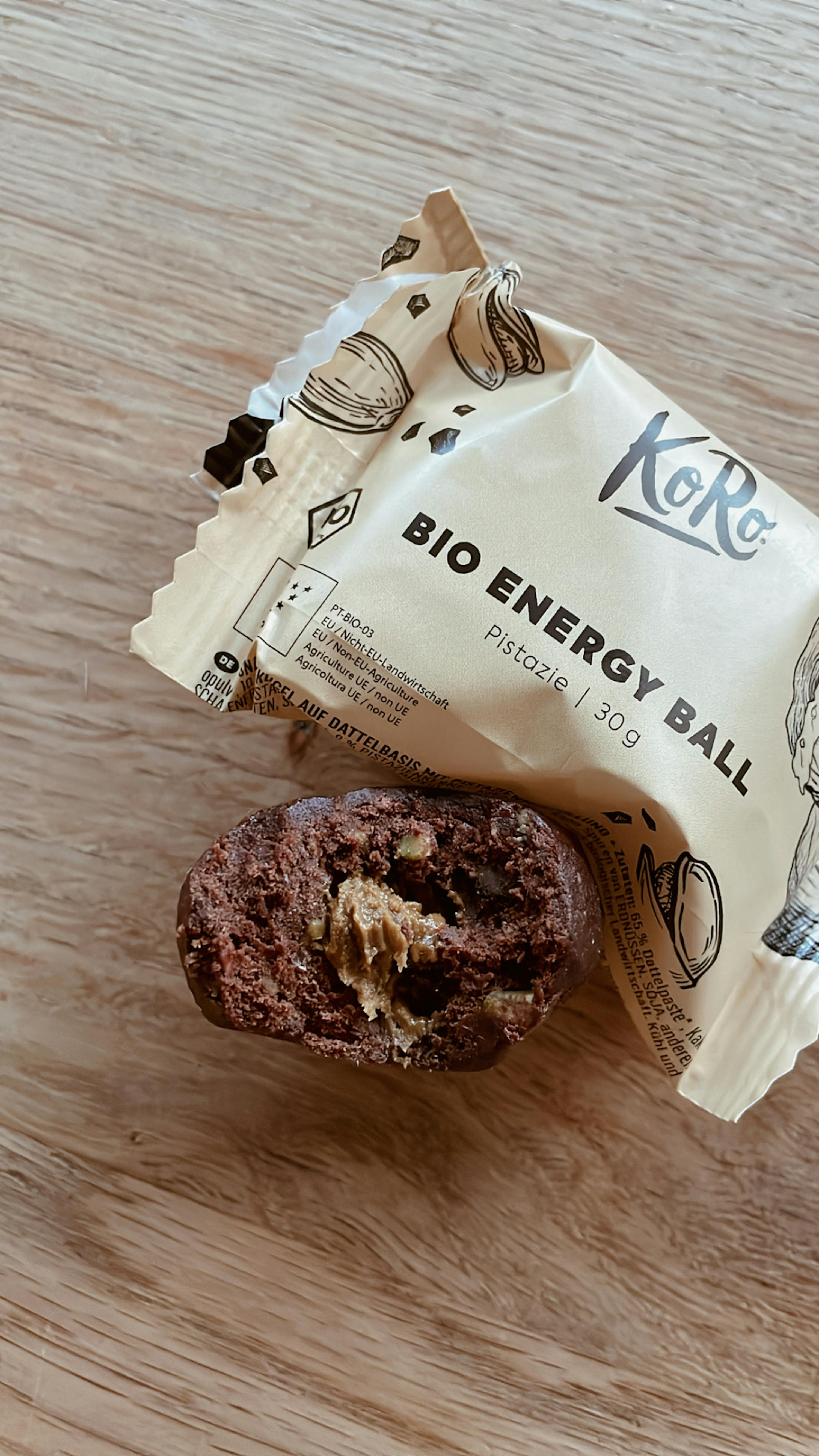 ein Bio-Energie-Ball aus pistazie liegt auf einem Holztisch
