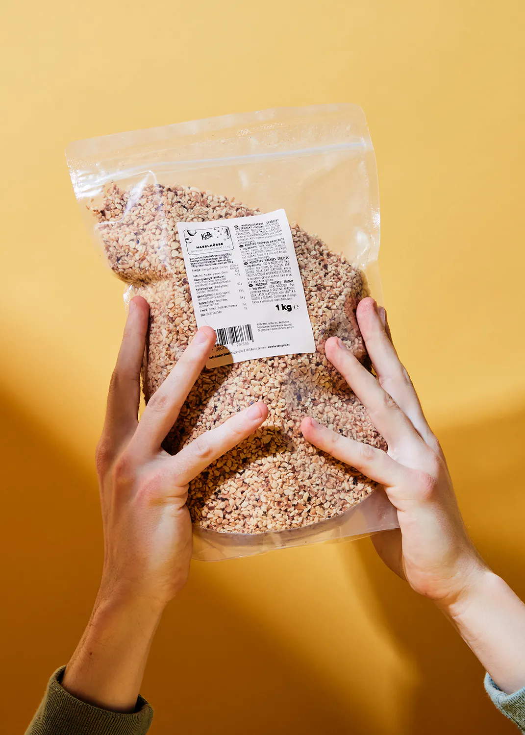 une personne tient un sac de nourriture avec une étiquette qui indique 1 kg