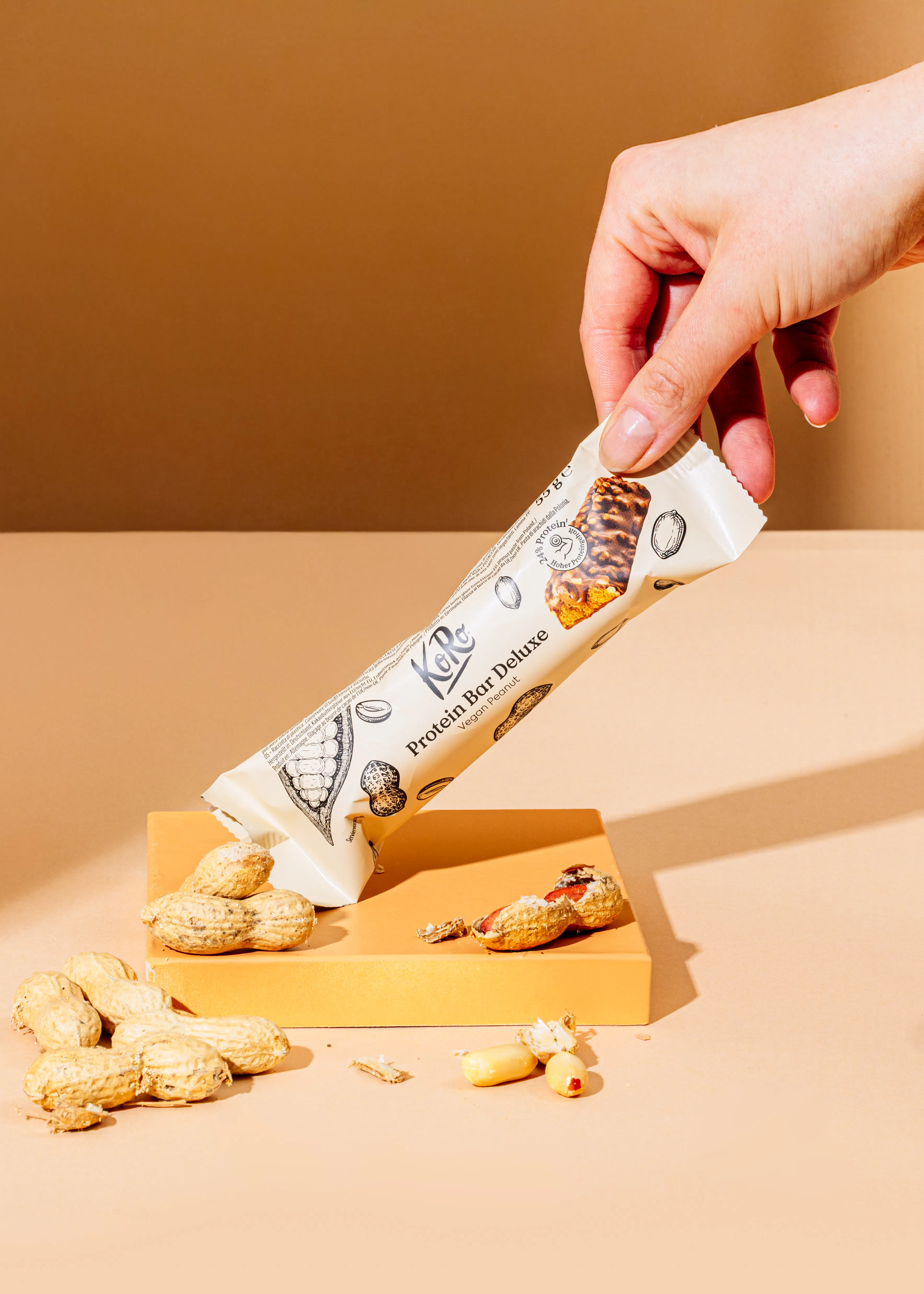 a person is holding a protein bar deluxe