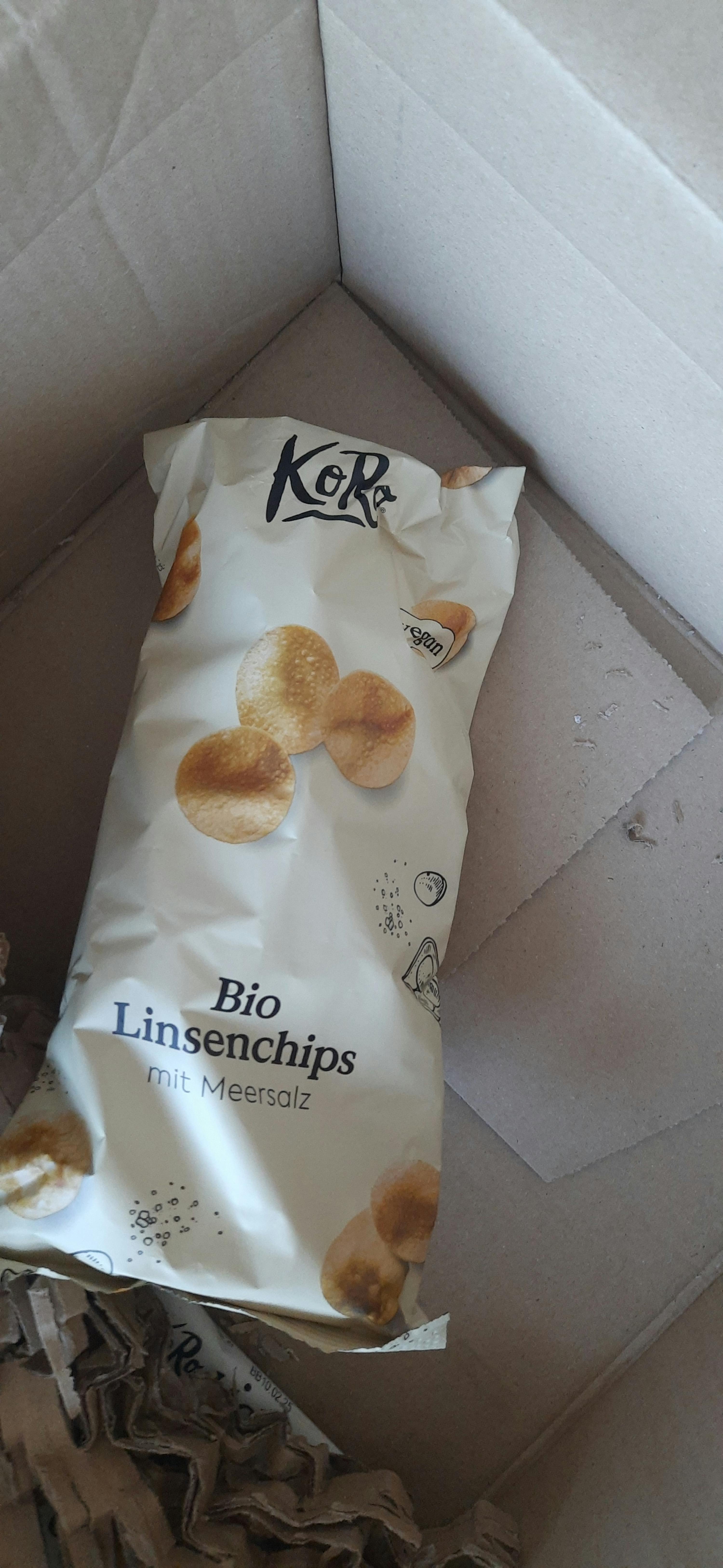 eine Tüte Linsenchips mit Meersalz liegt auf einem Karton