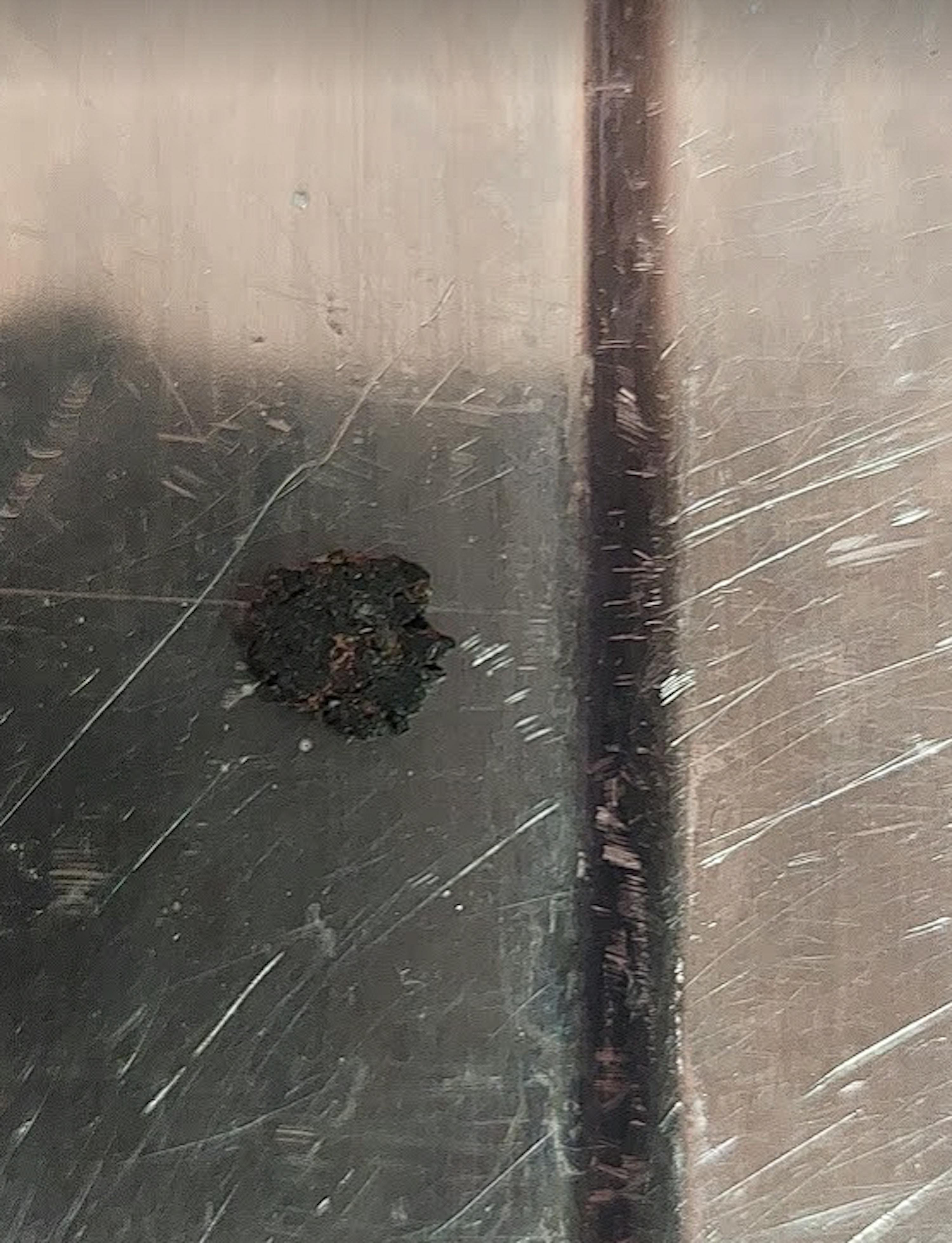 un gros plan d' une surface en acier inoxydable avec un trou au milieu